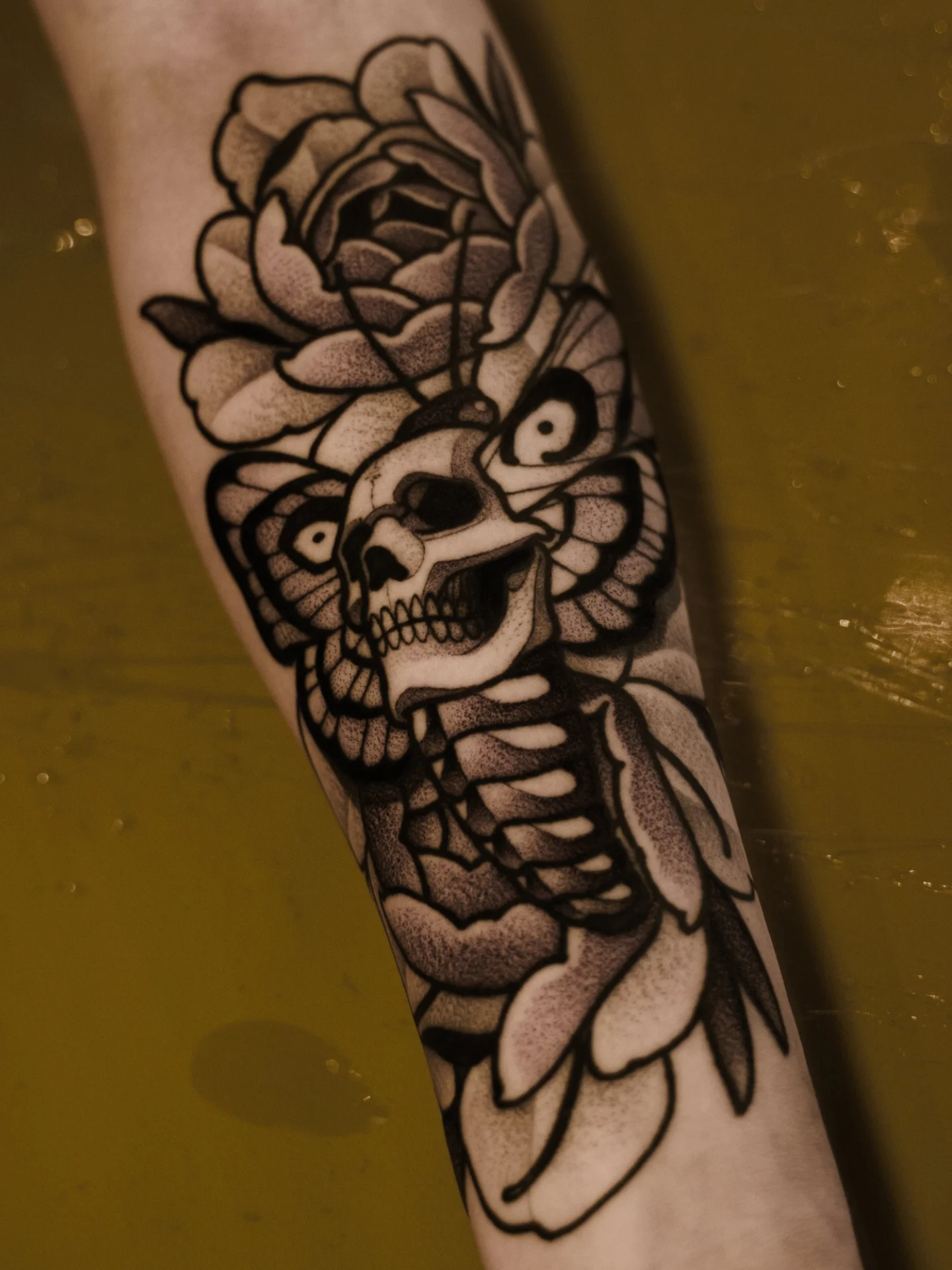 Skull and flower black and grey tattoo on the forearm by Craig St Peter, Kansas City, Missouri