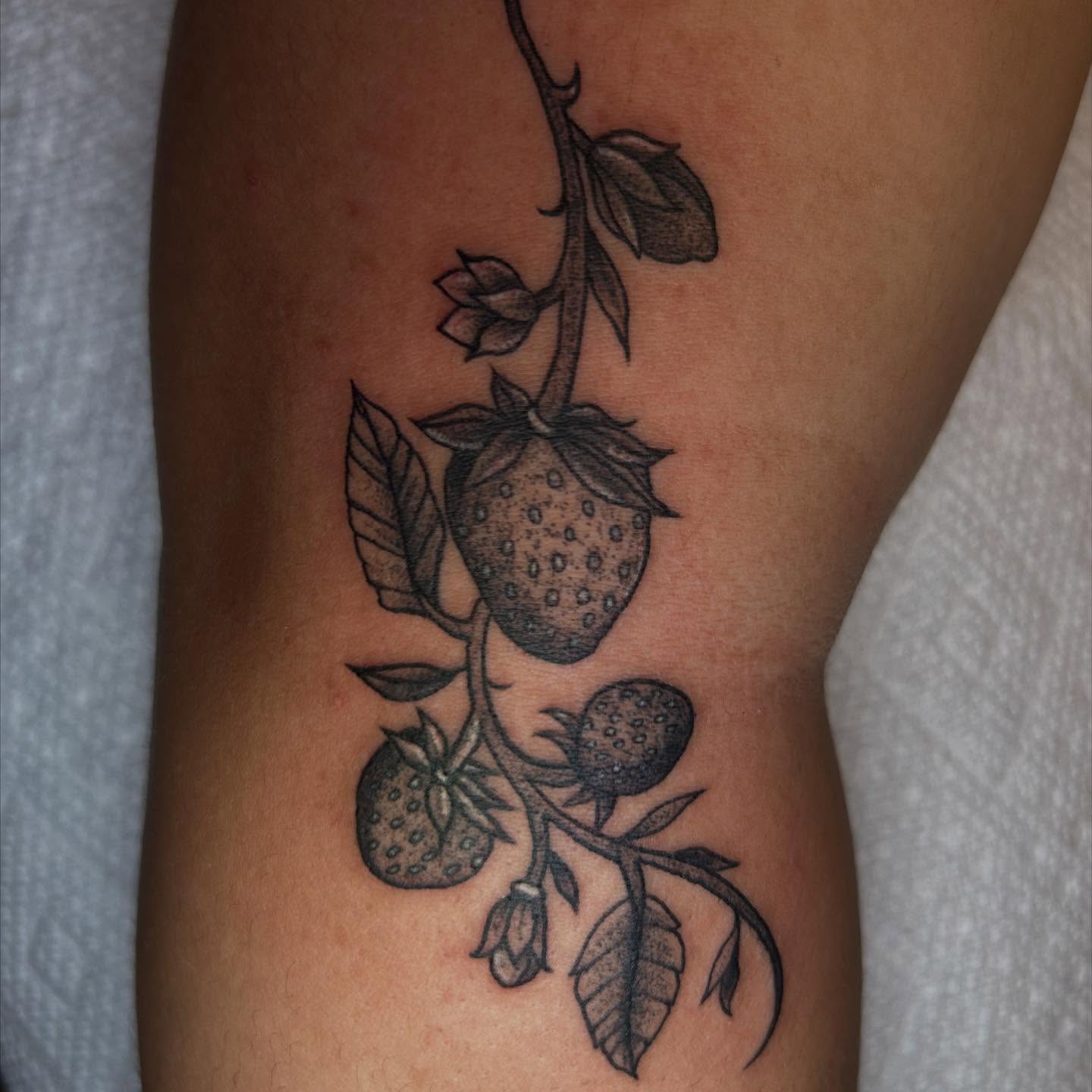 Strawberry plant black and grey tattoo on the forearm by Ashley Lambert
