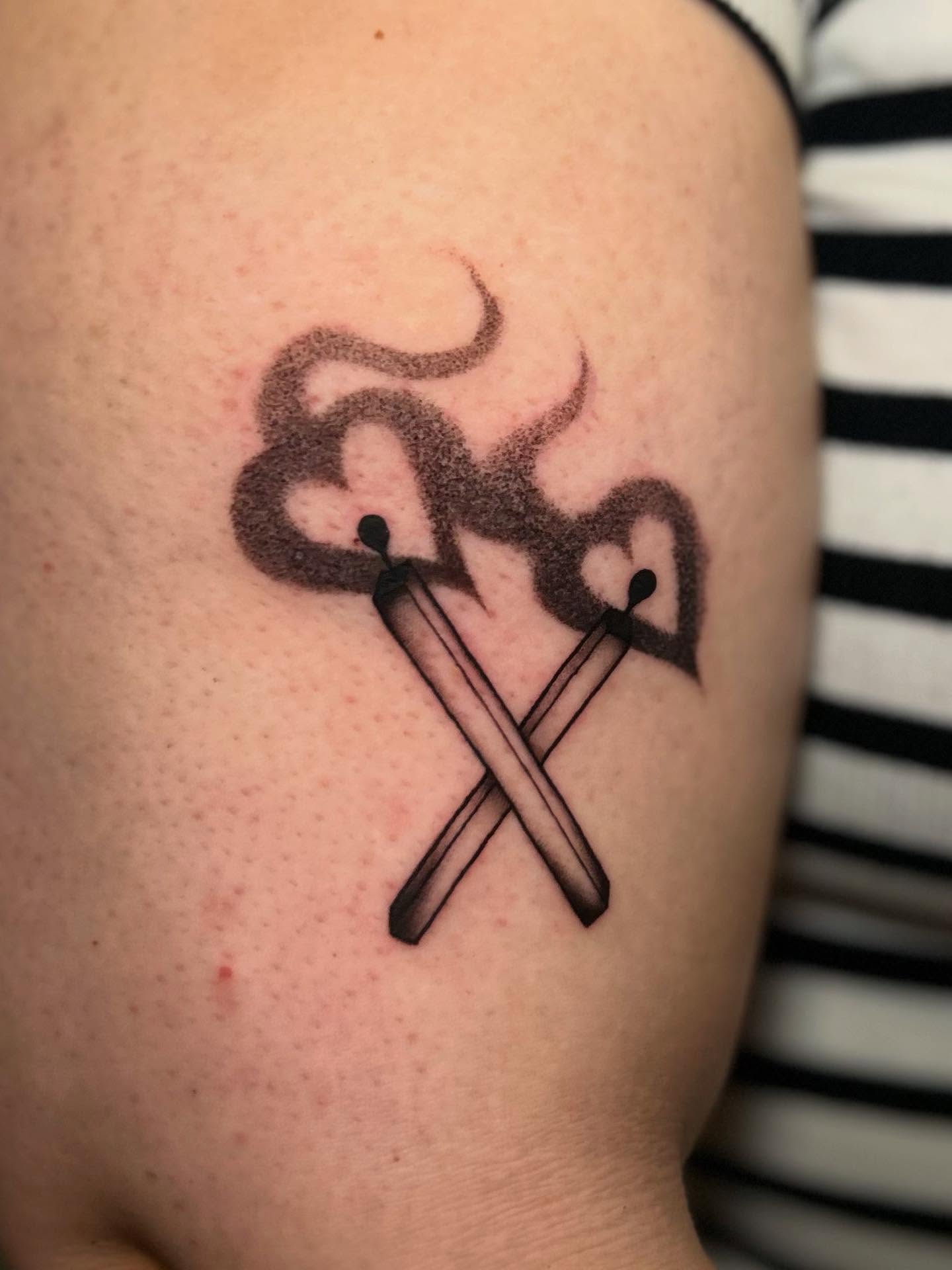 Matches and heart black and grey tattoo on the shoulder by Chloe