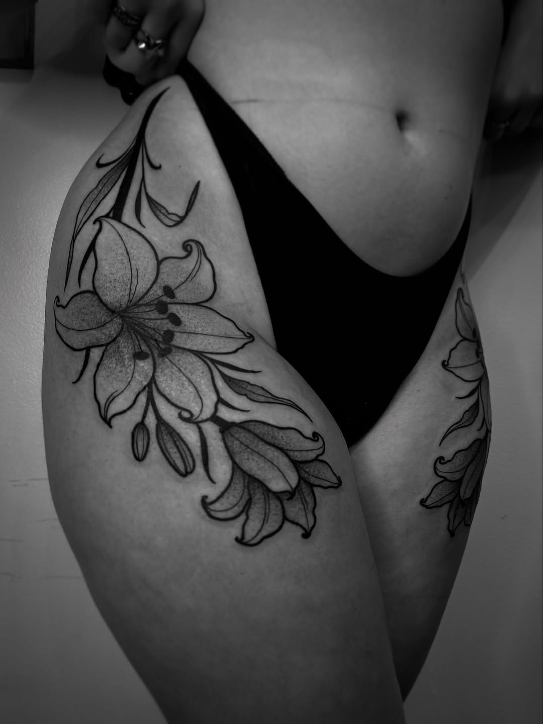 Lily flowers fine line tattoo on the thigh by Eden H., Columbus, Ohio