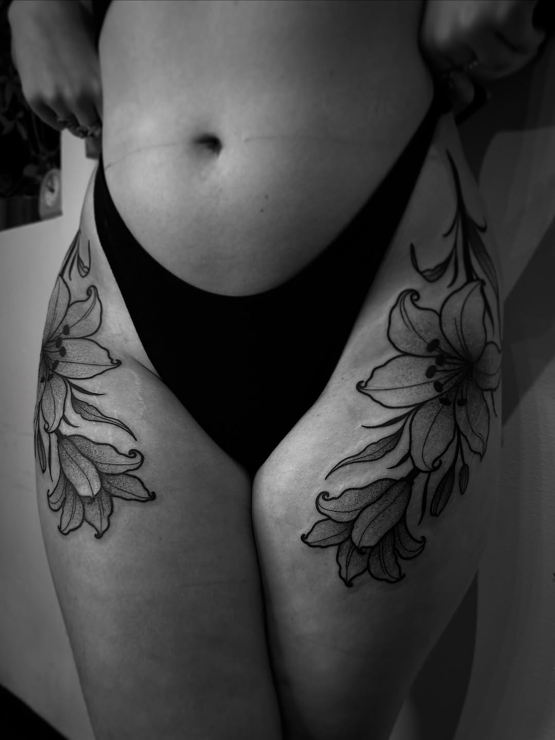 Lily flowers fine line tattoo on the thigh by Eden H., Columbus, Ohio