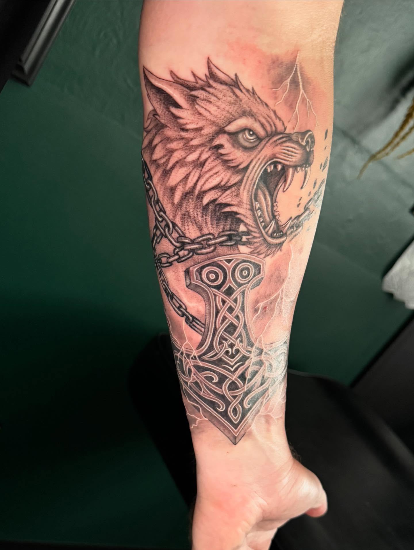 Wolf head and hammer realism tattoo on the forearm by Leslea Hipp