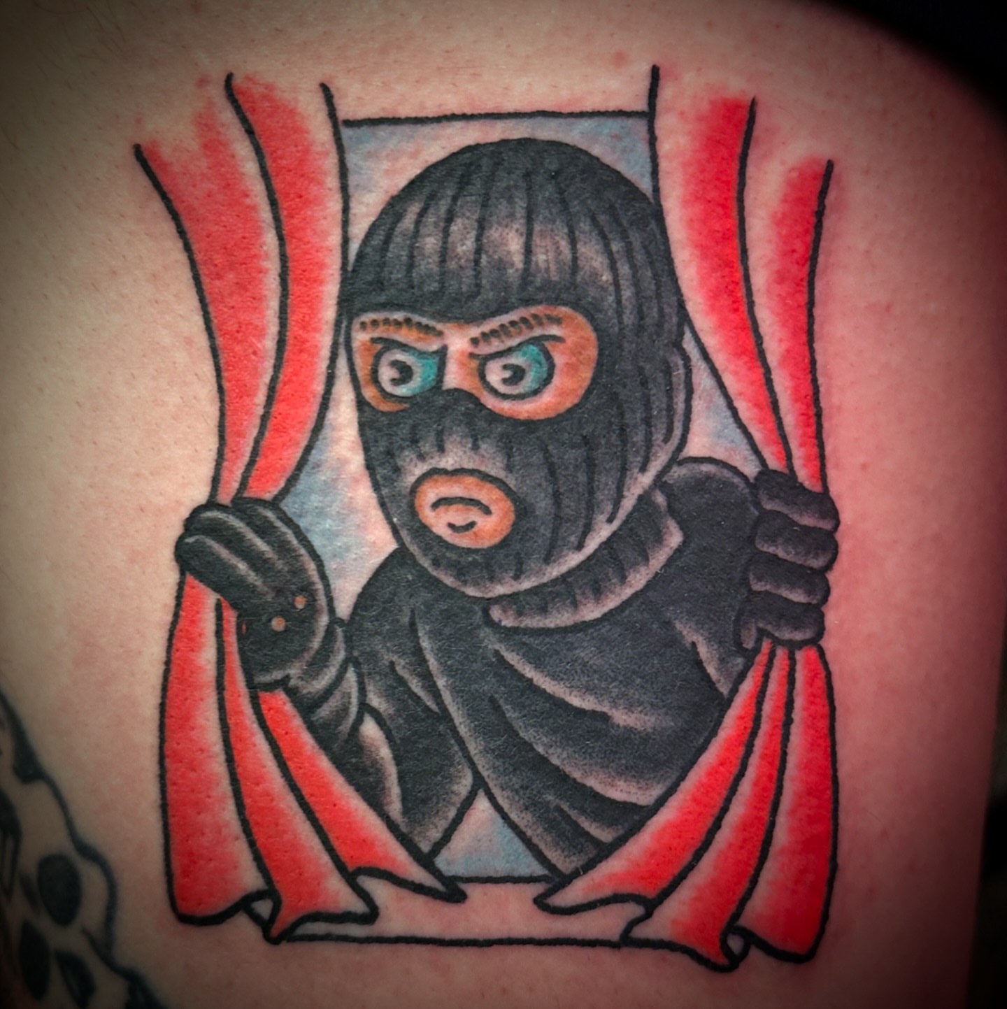 Masked figure American traditional tattoo on the shoulder by Chris Blanchard