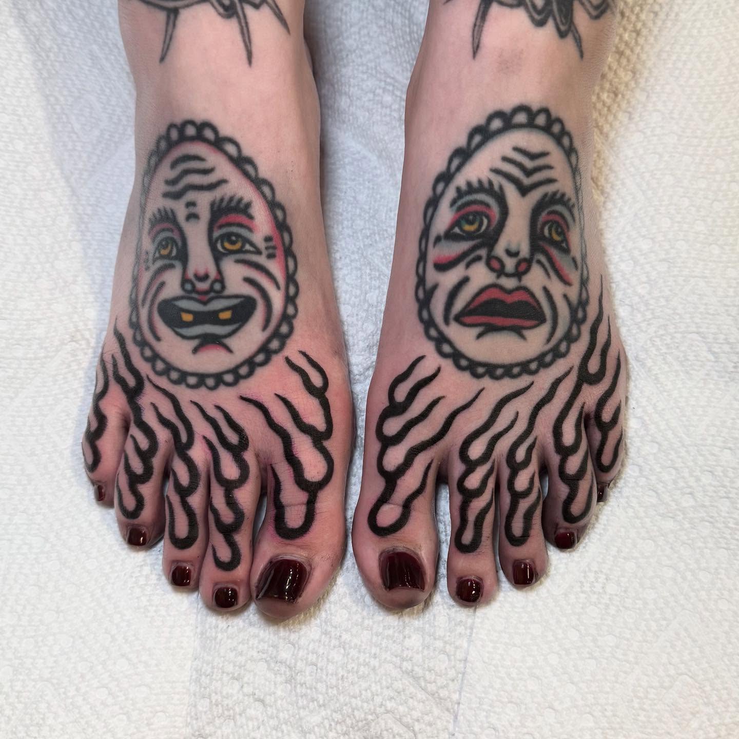 Clown faces American traditional tattoo on the foot by Julia Louise