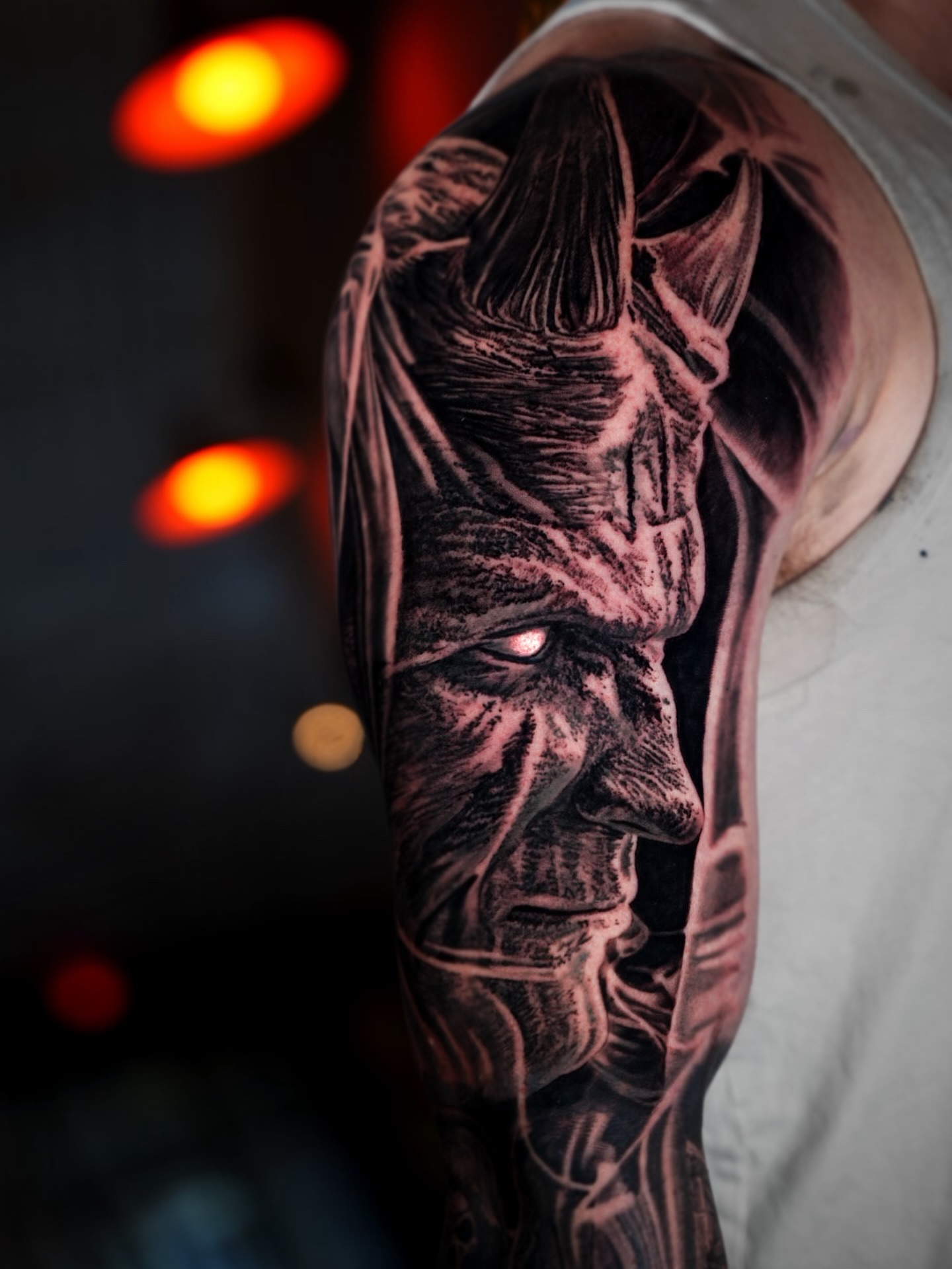 Demon face realism tattoo on the upper arm by Bailey Lemus