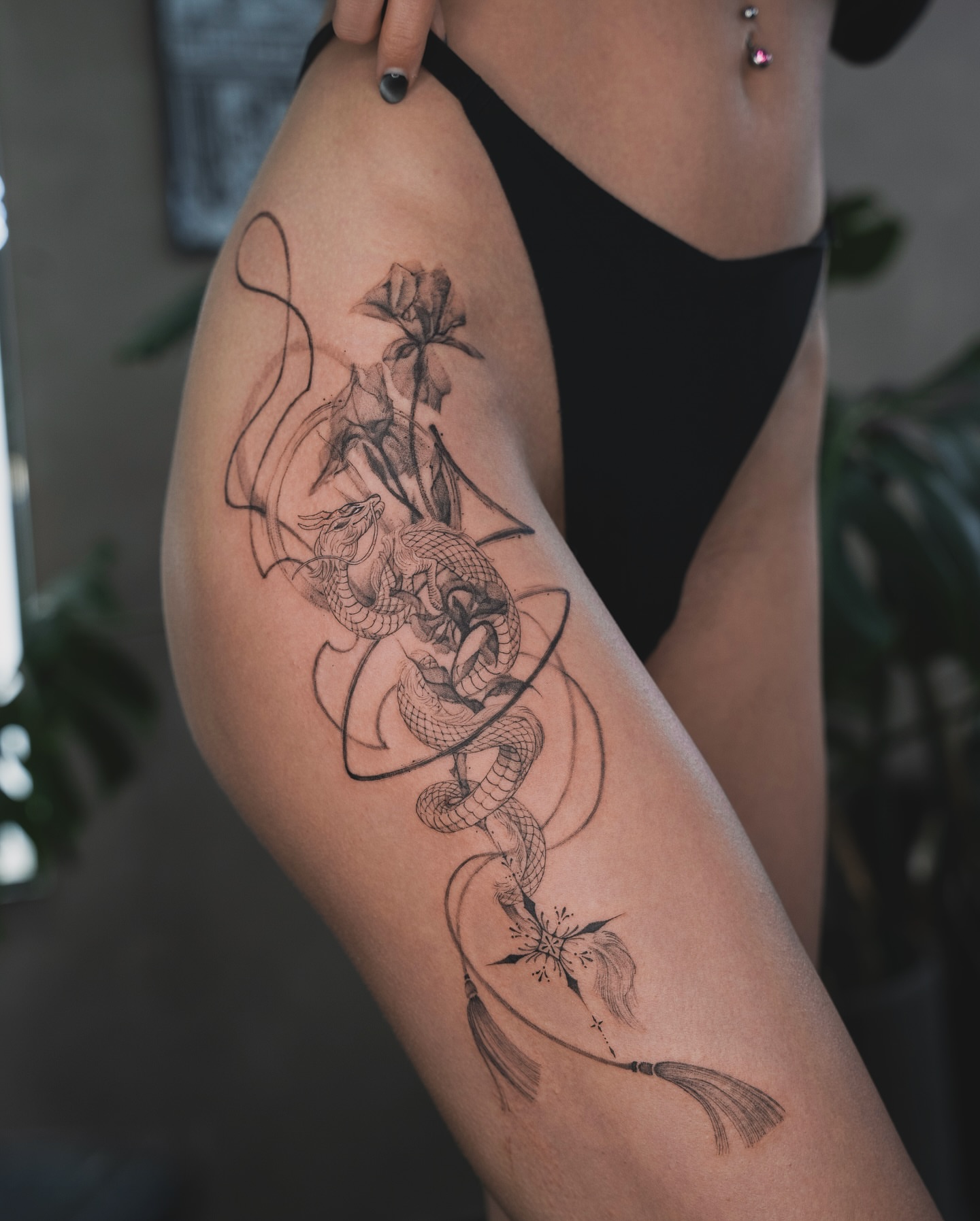 Dragon and flower realism tattoo on the thigh by Tri