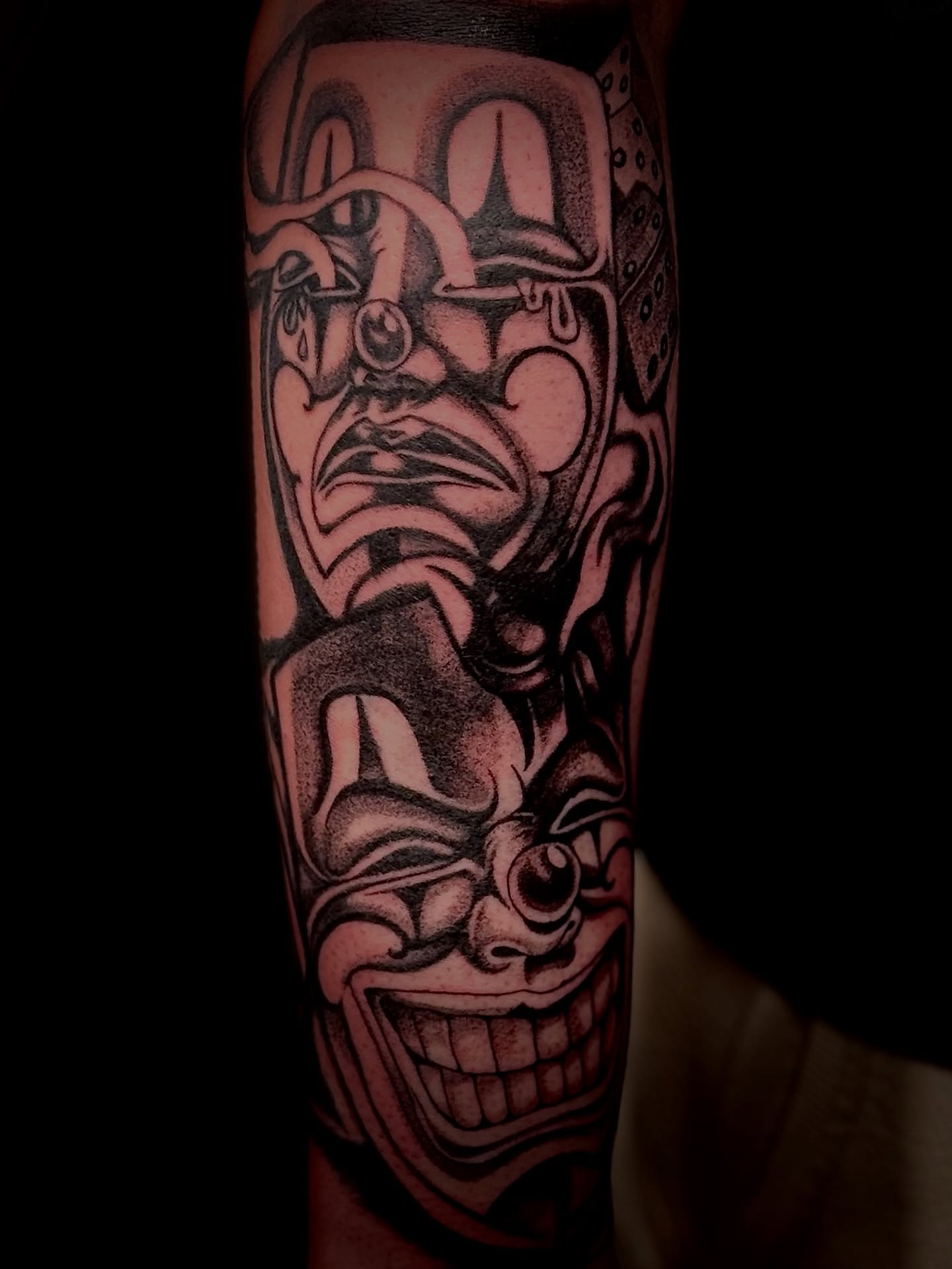 Clown mask black and grey tattoo on the forearm by Виктория Лукьянова
