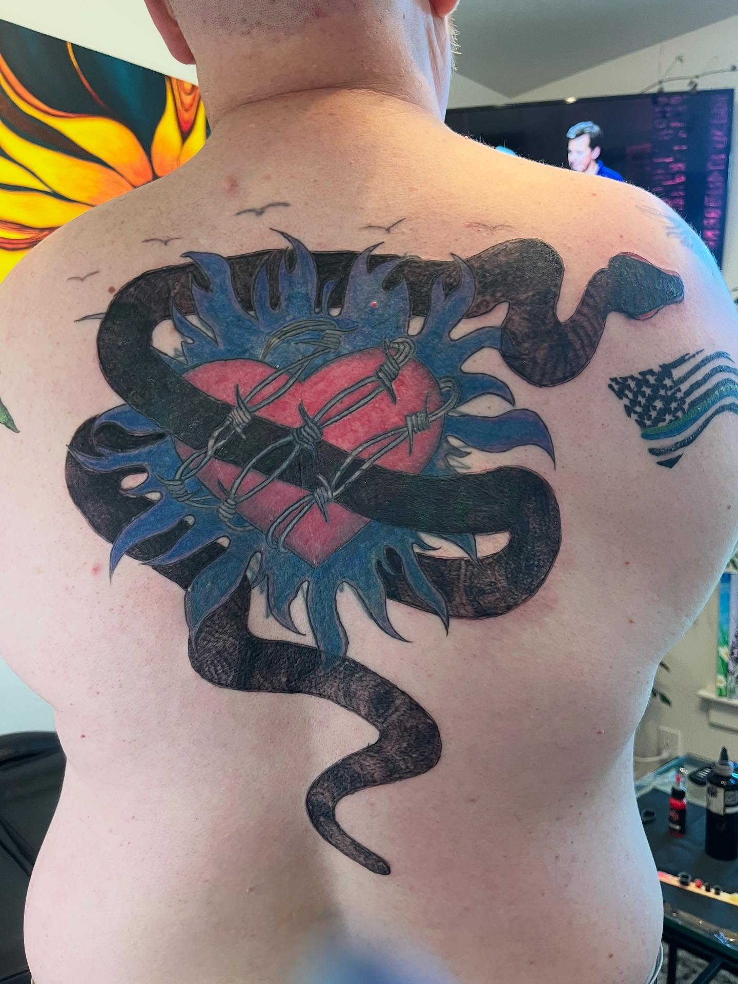 Snake and heart black and grey tattoo on the back by Val Maughan