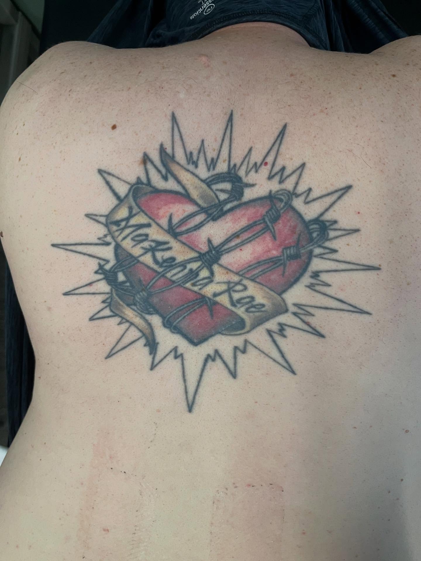 Heart with barbed wire American traditional tattoo on the back by Val Maughan