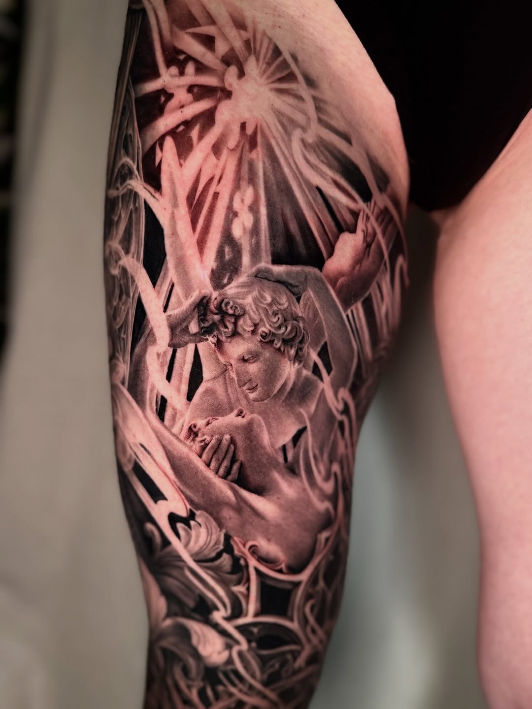 Angelic figures in dramatic light realism tattoo on the forearm by April Lynn