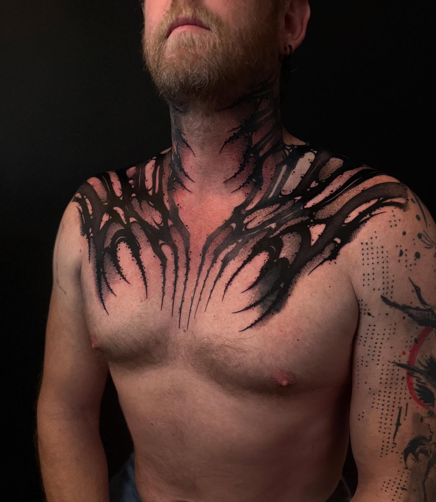 Flame blackwork tattoo on the chest by Dylan Orbock, Berkeley, California