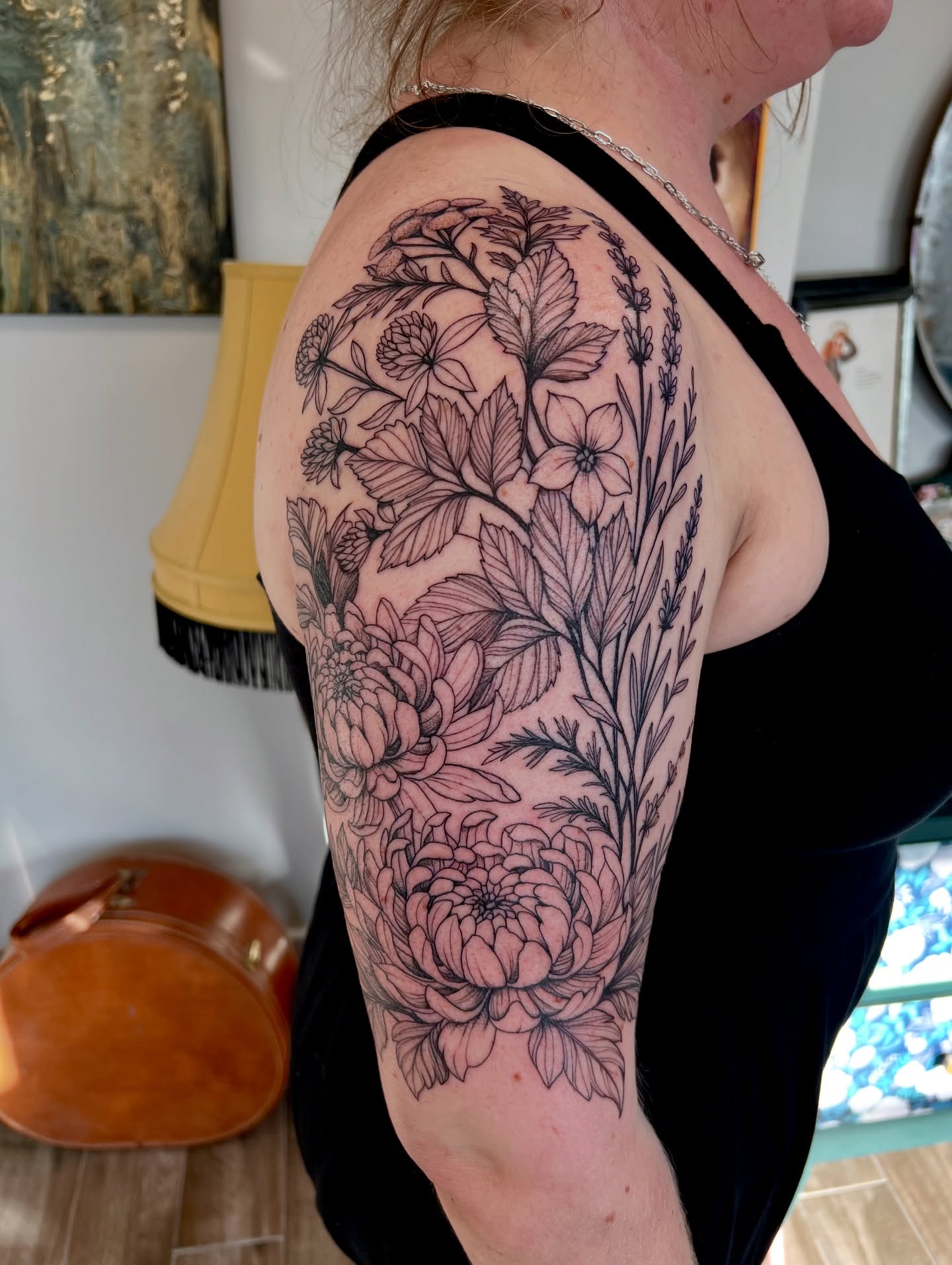 Floral bouquet black and grey tattoo on the upper arm by Amanda Morris