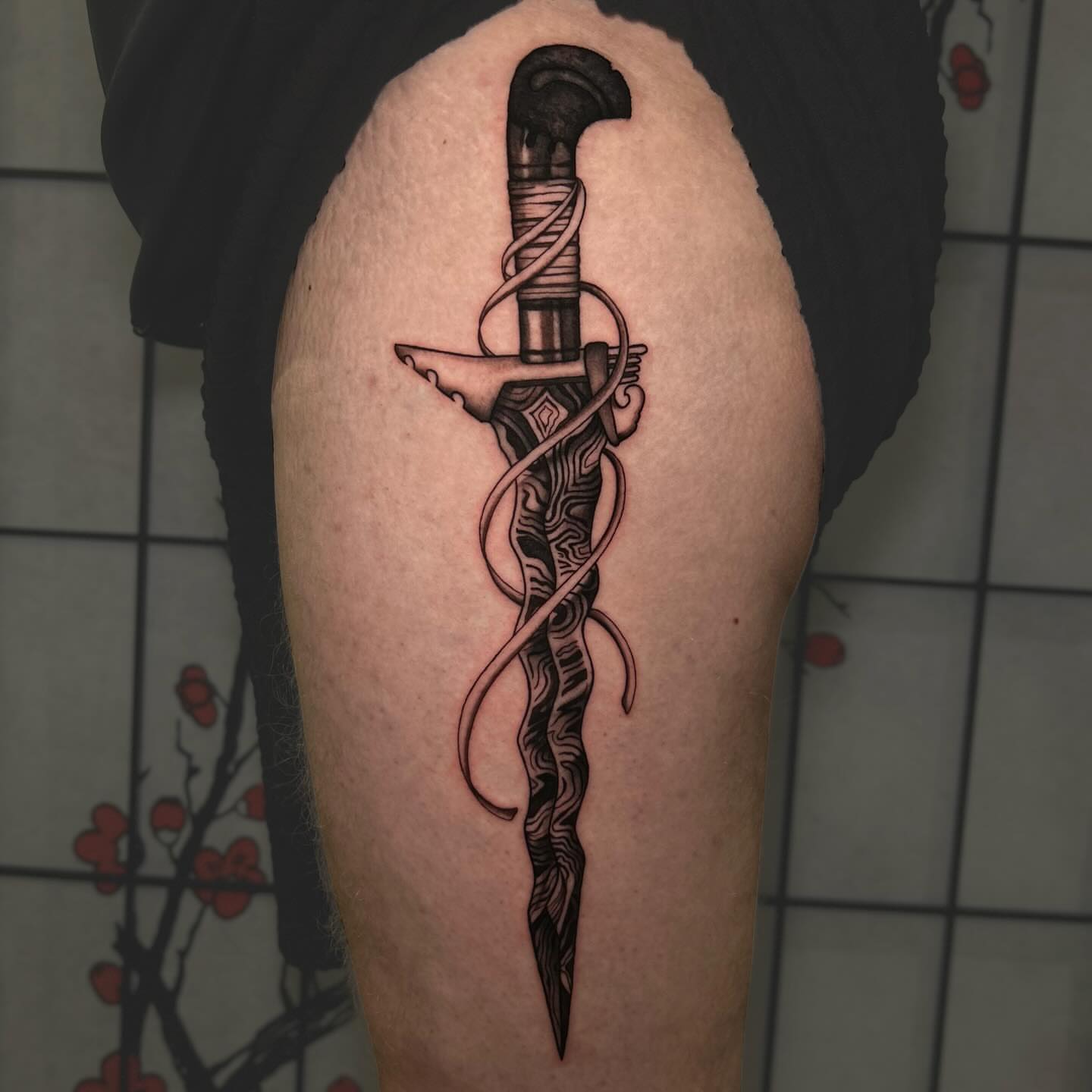 Sword black and grey tattoo on the thigh by Chloe