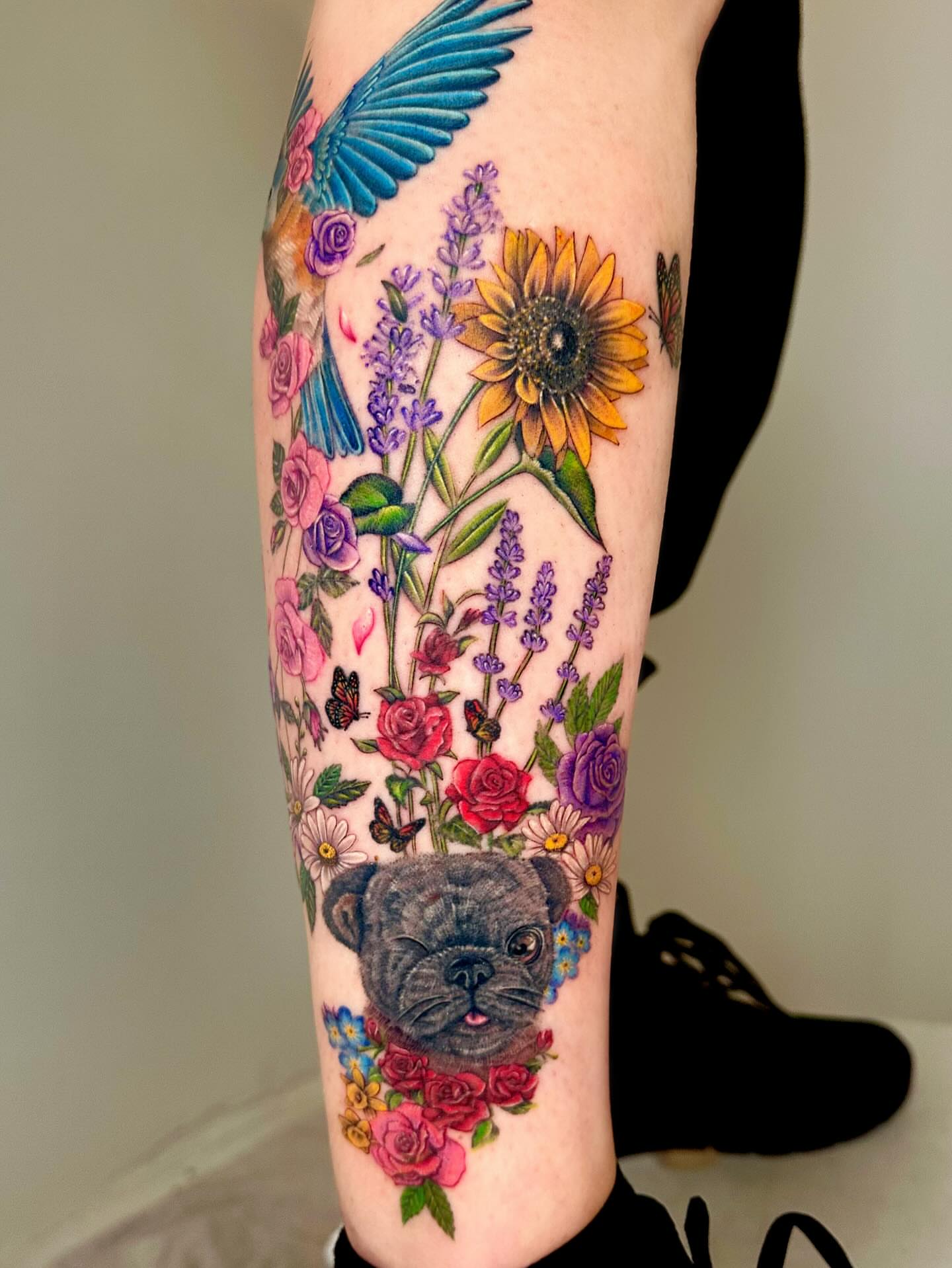Dog with flowers realism tattoo on the forearm by Claire