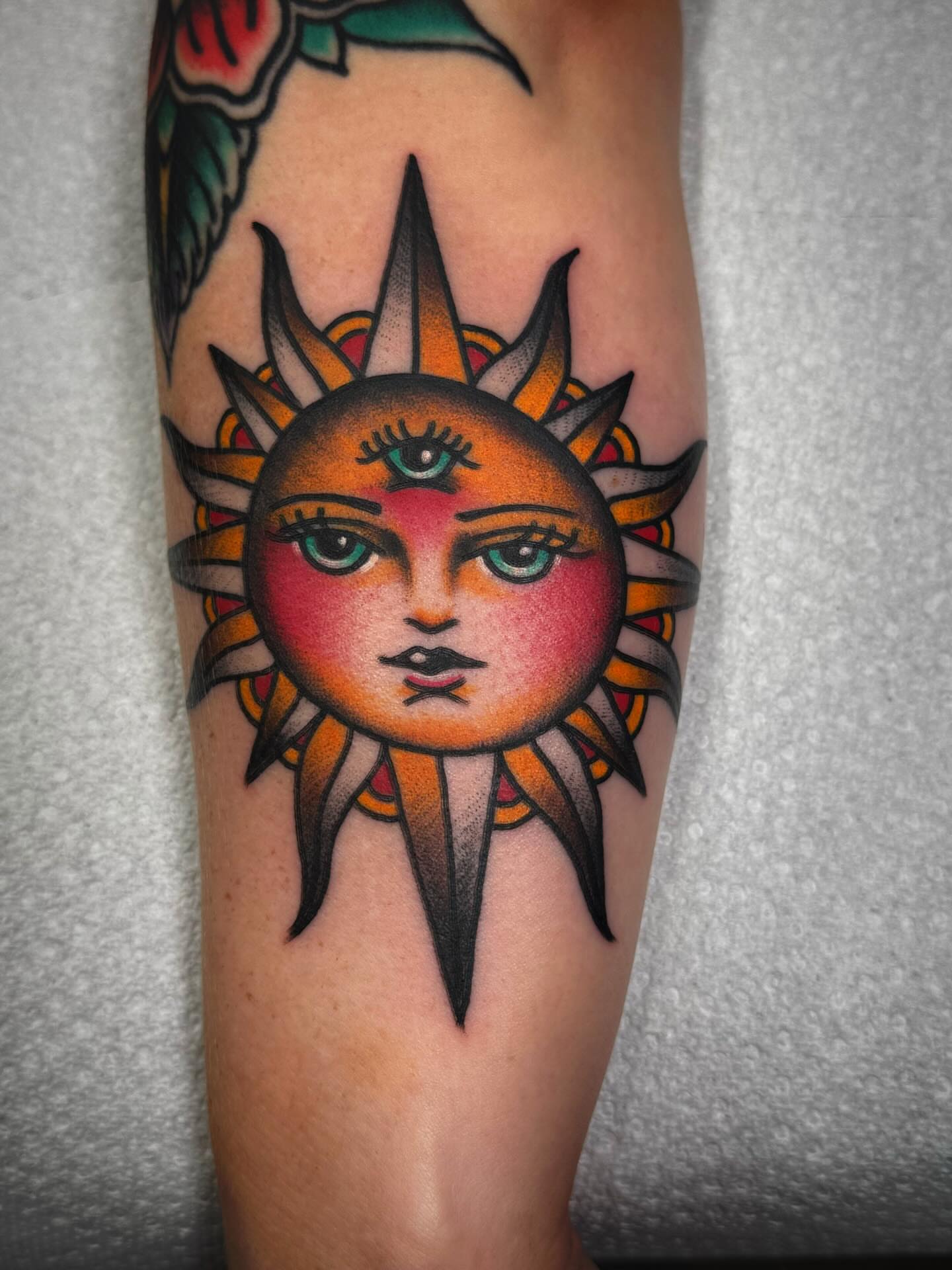 Sun with face American traditional tattoo on the forearm by Mikey Sarratt