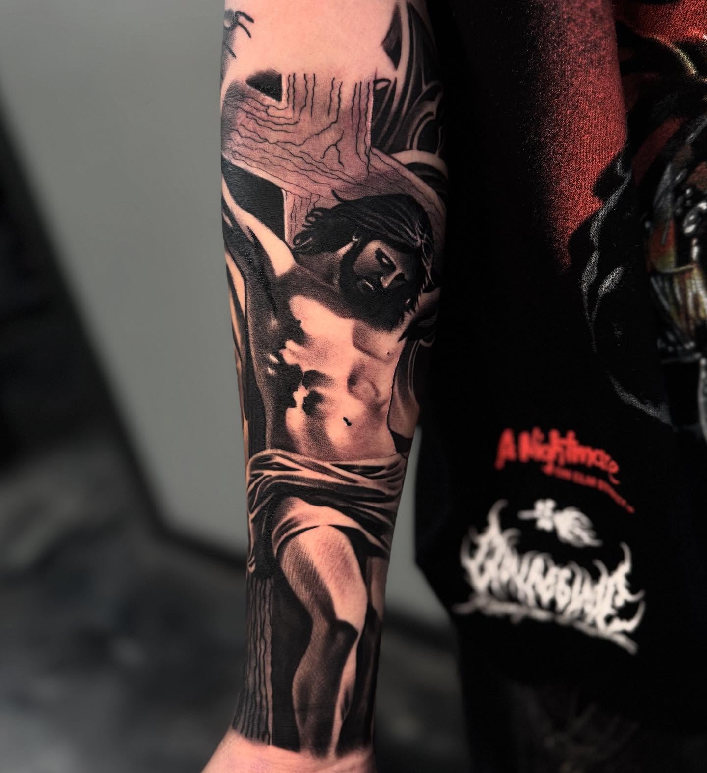 Jesus Christ on the cross realism tattoo on the forearm by Angel Damian Parada