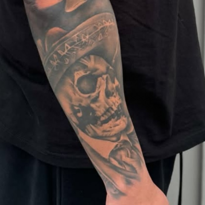 Skull wearing hat realism tattoo on the forearm by Angel Pineda-Rodriguez