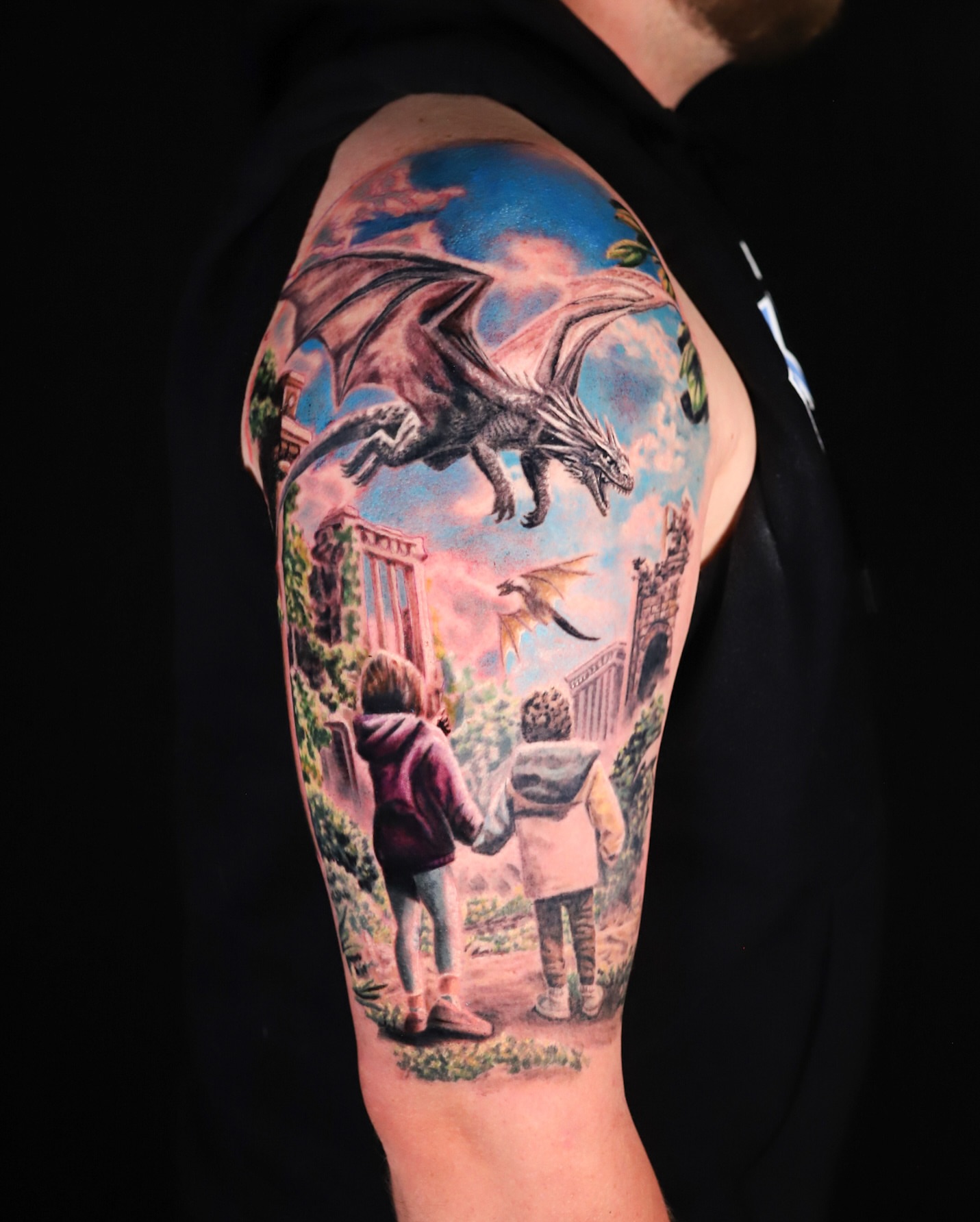 Children and dragons realism tattoo on the upper arm by Ava Grace