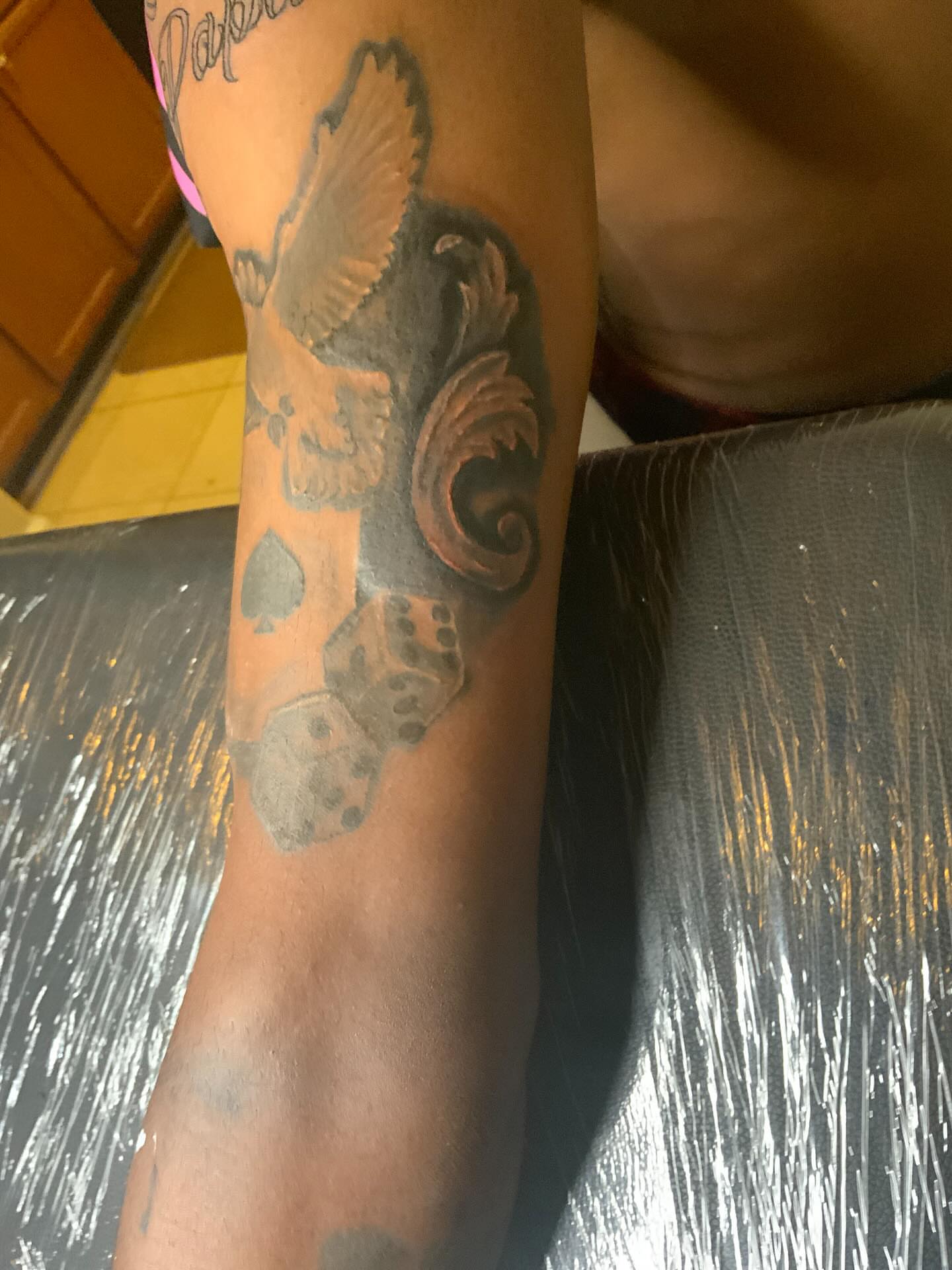 Bird and dice black and grey tattoo on the forearm by Illuminink.gallery