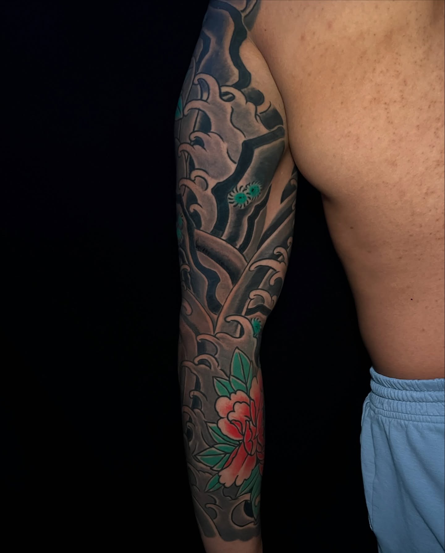 Wave and flower japanese irezumi tattoo on the forearm by Andrew Snowden