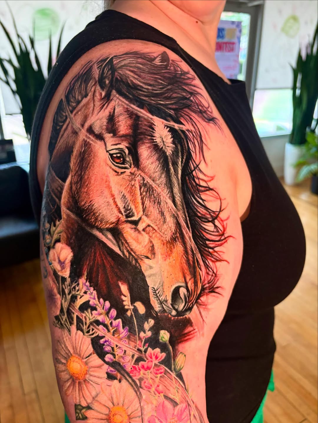 Horse head with flowers watercolor tattoo on the upper arm by Jacee Hamilton