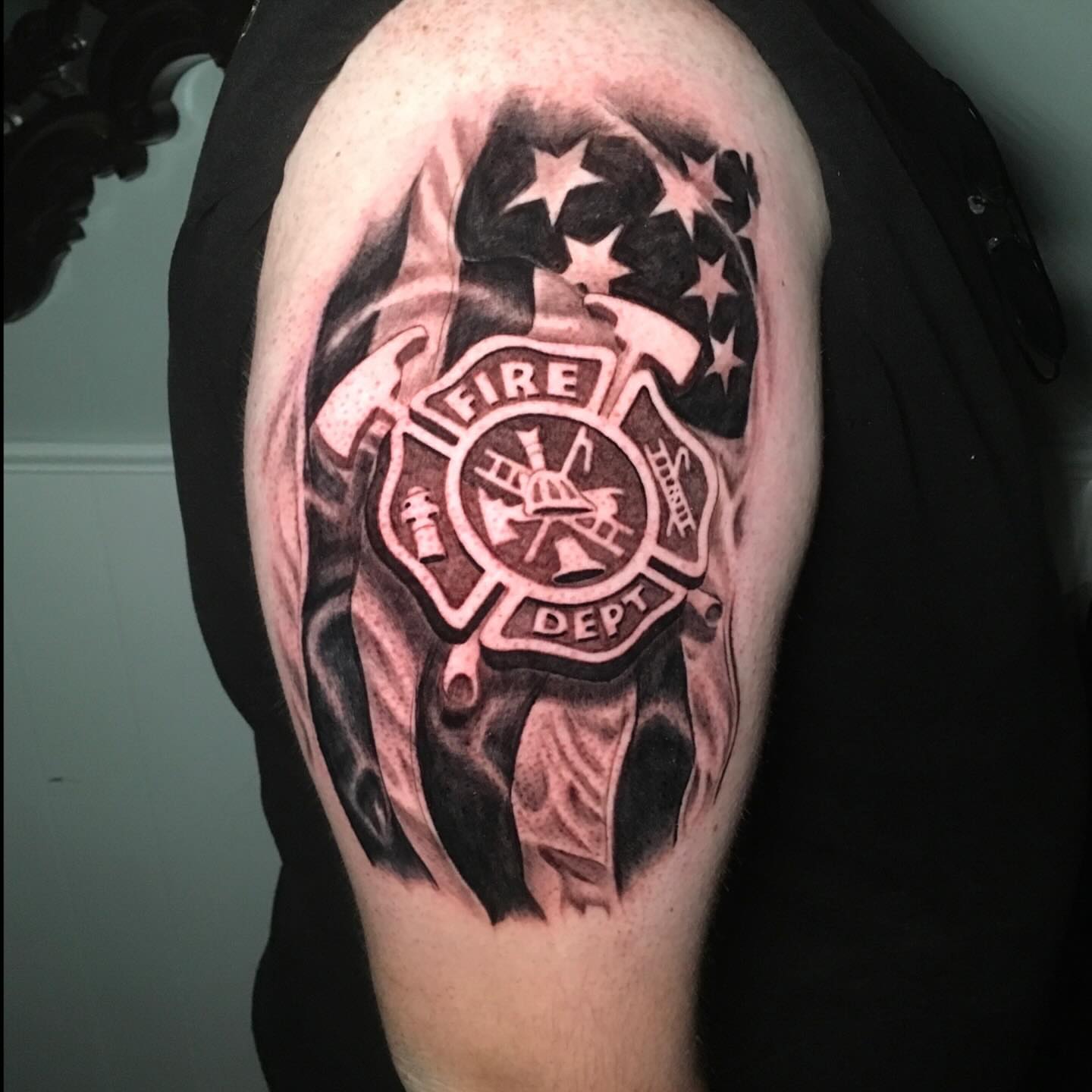 Fire department badge realism tattoo on the shoulder by Joshua Shawn