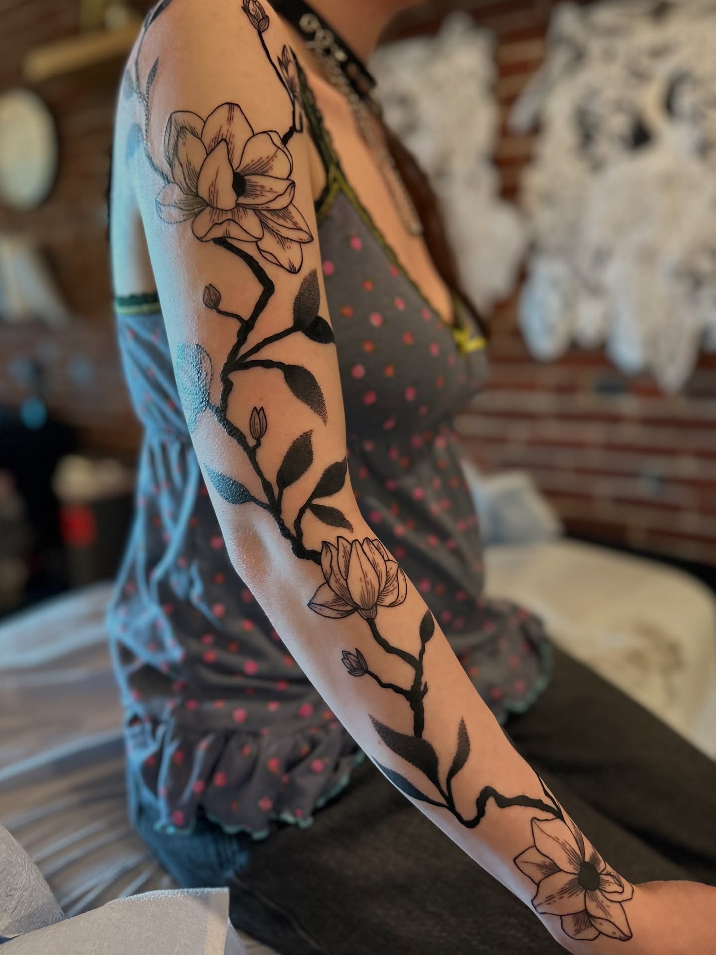 Magnolia flowers black and grey tattoo on the forearm by Alexandra Gray