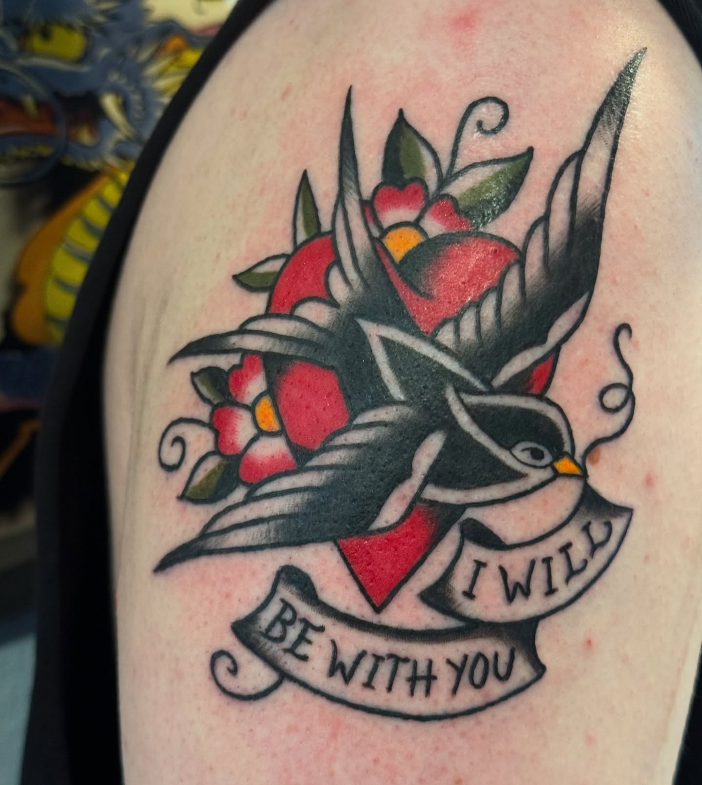 Bird and flowers American traditional tattoo on the upper arm by Kelsey Turnis