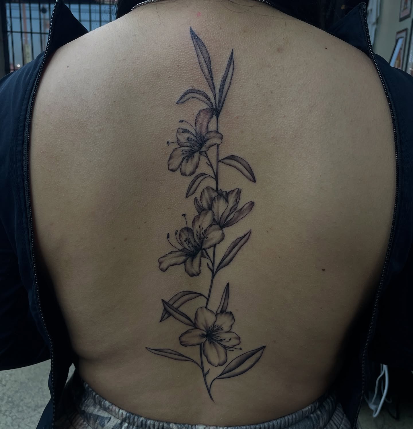 Flowers black and grey tattoo on the back by kaylee