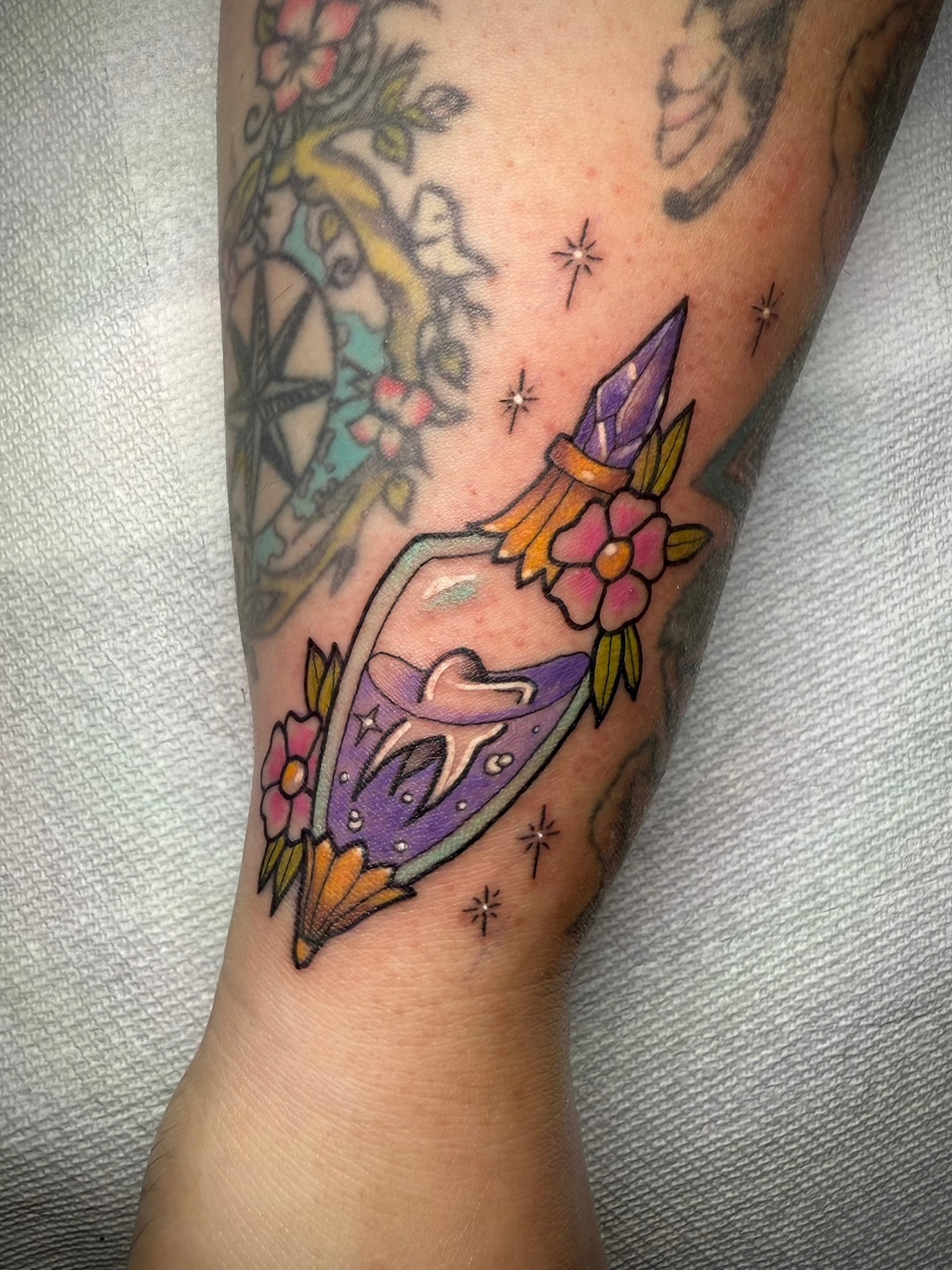 Rocket with crystals American traditional tattoo on the forearm by Ashley Laine Evans