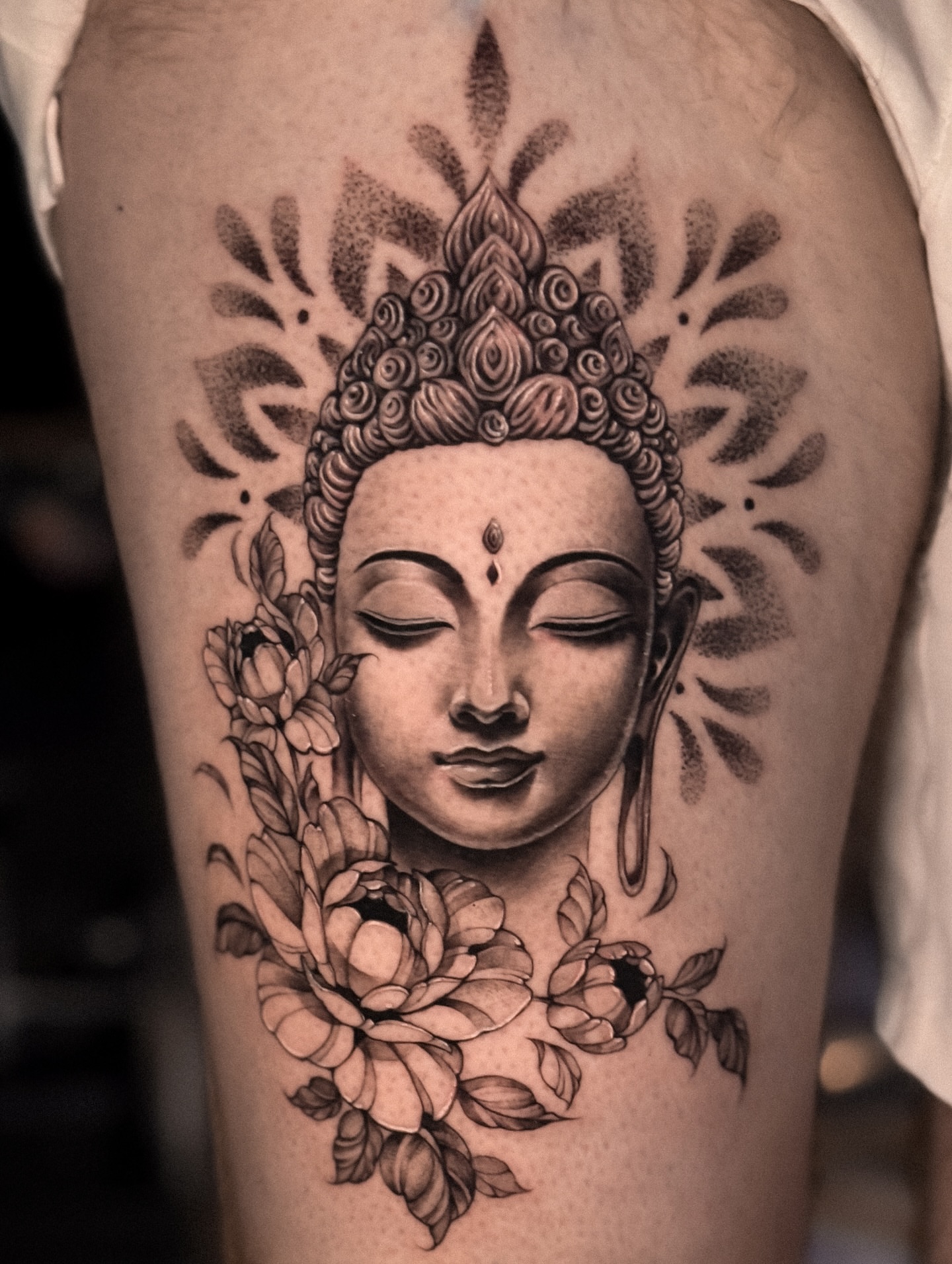 Buddha head with lotus flowers dotwork tattoo on the thigh by πππΉππππππππππππ