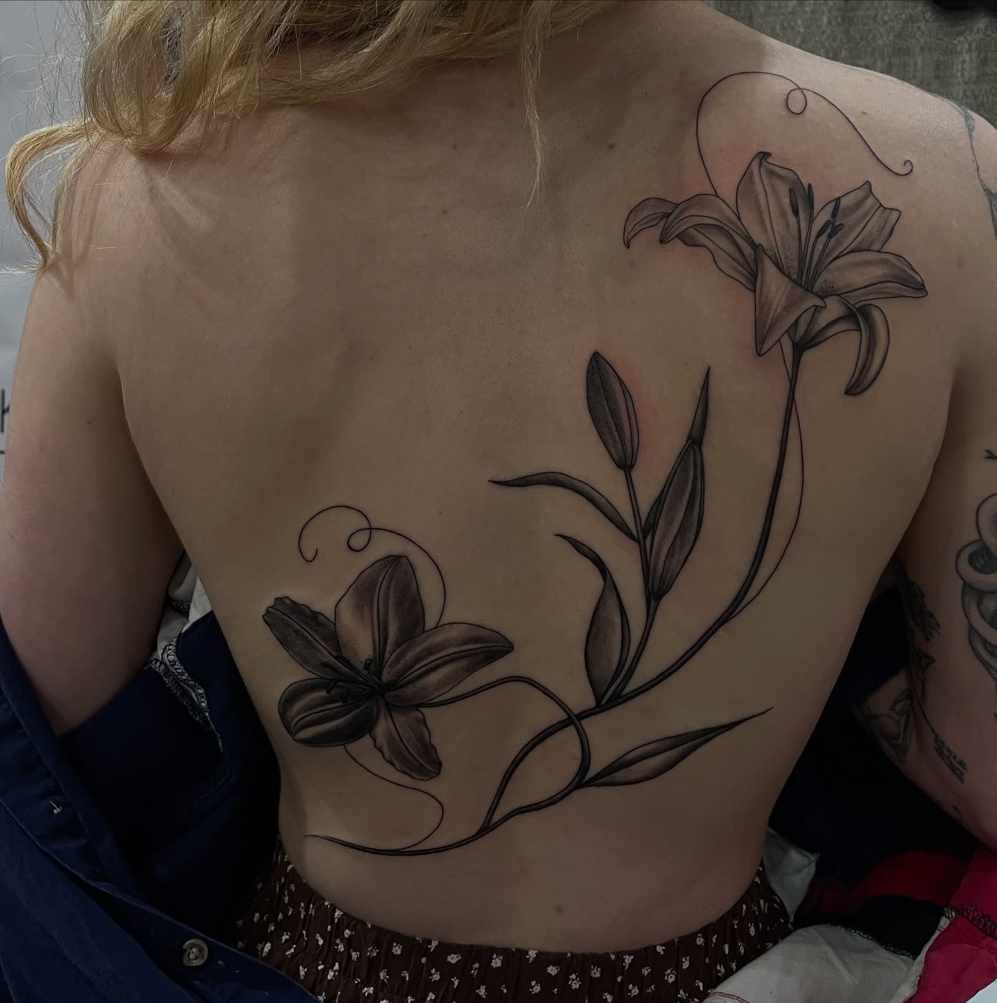 Lily flowers realism tattoo on the back by kaylee