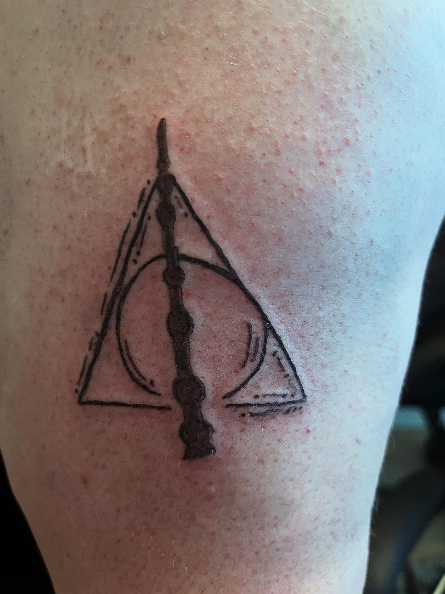 Deathly hallows symbol geometric tattoo on the upper arm by Val Maughan