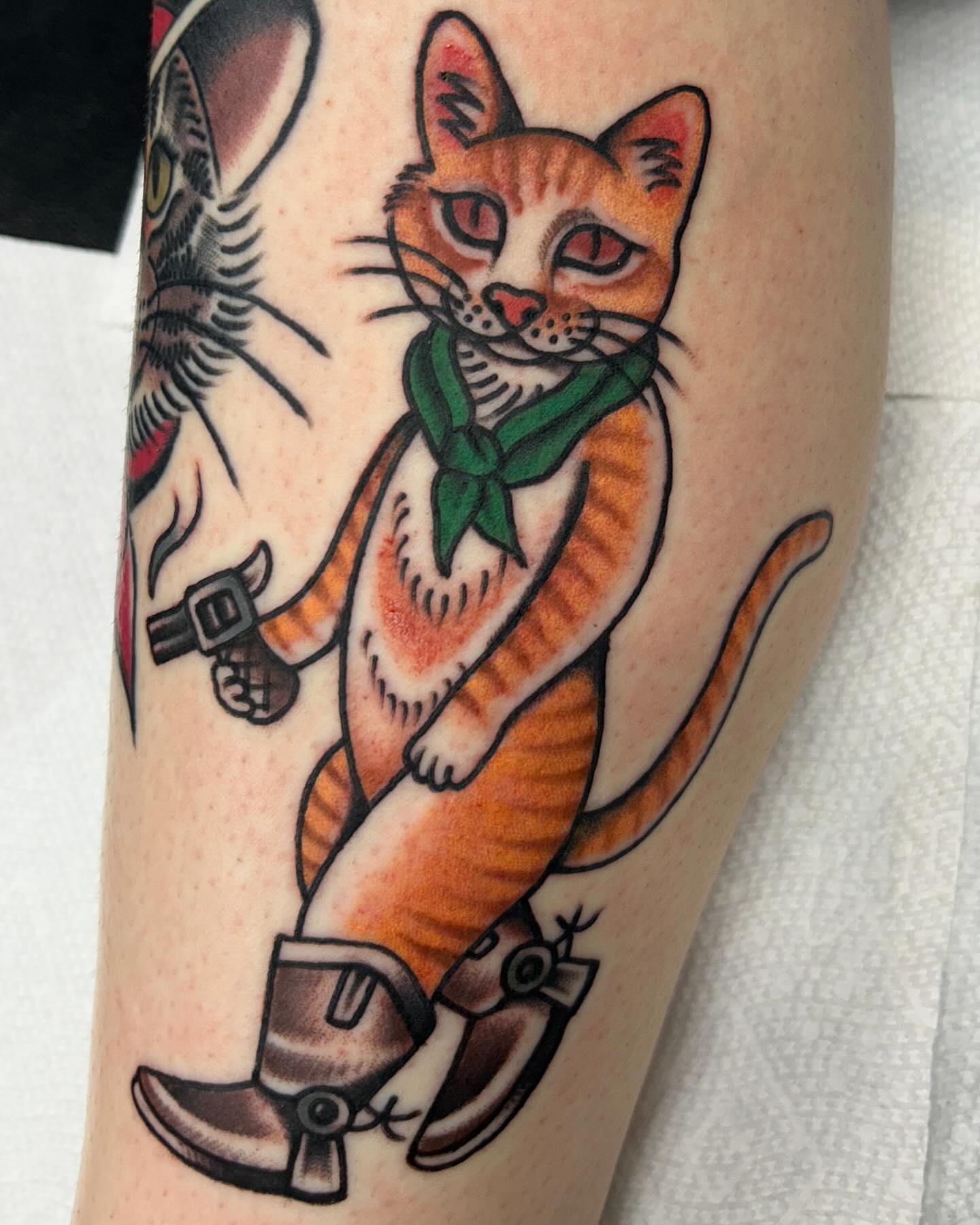 Cat wearing cowboy boots American traditional tattoo on the forearm by Tiffany Vargas