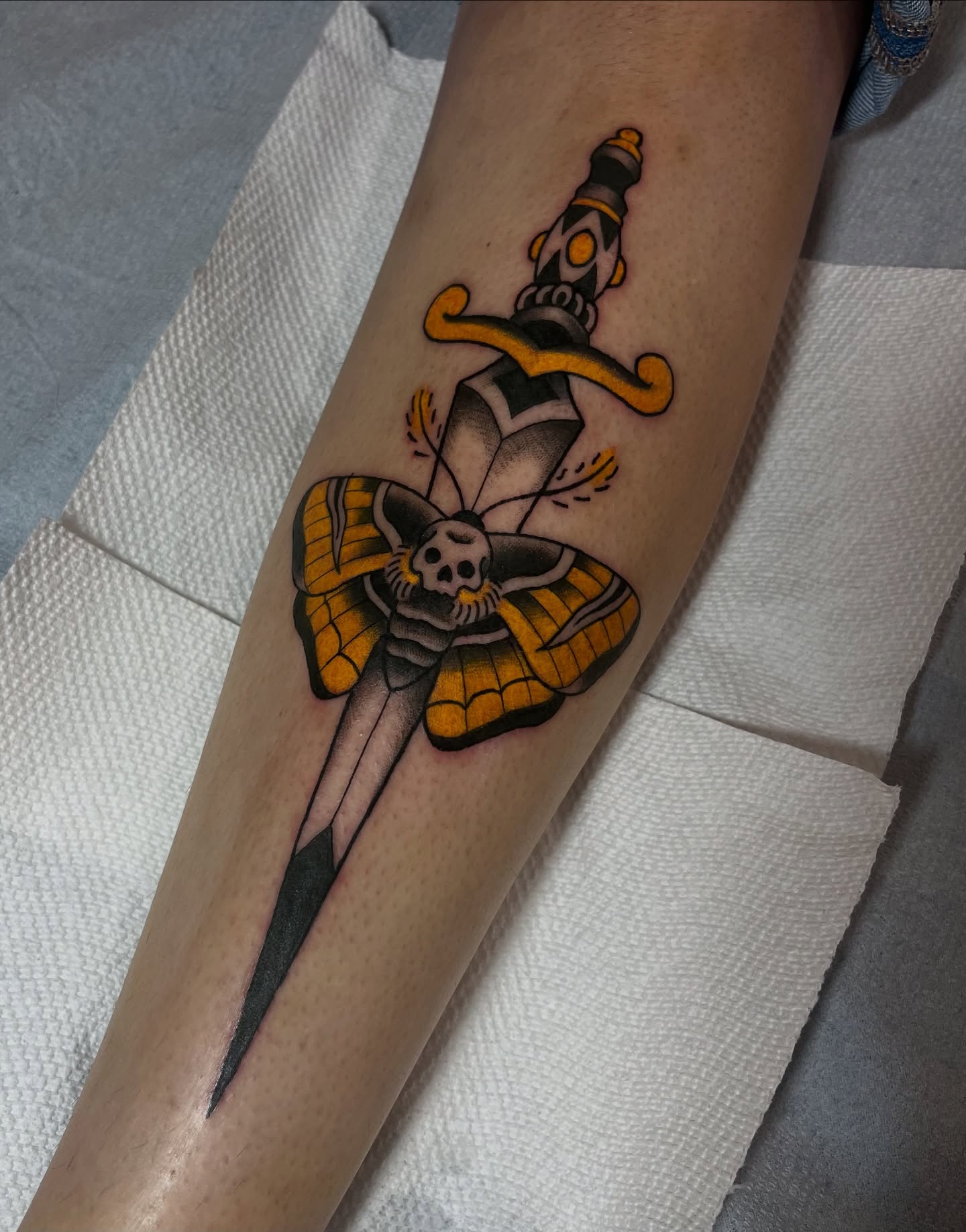 Knife and moth American traditional tattoo on the forearm by Taylor Newton