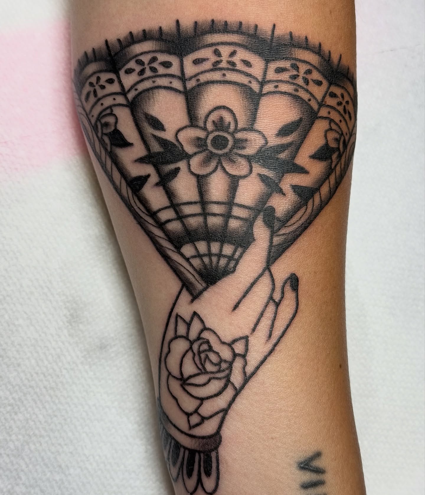 Fan and hand American traditional tattoo on the forearm by Kelsey Turnis