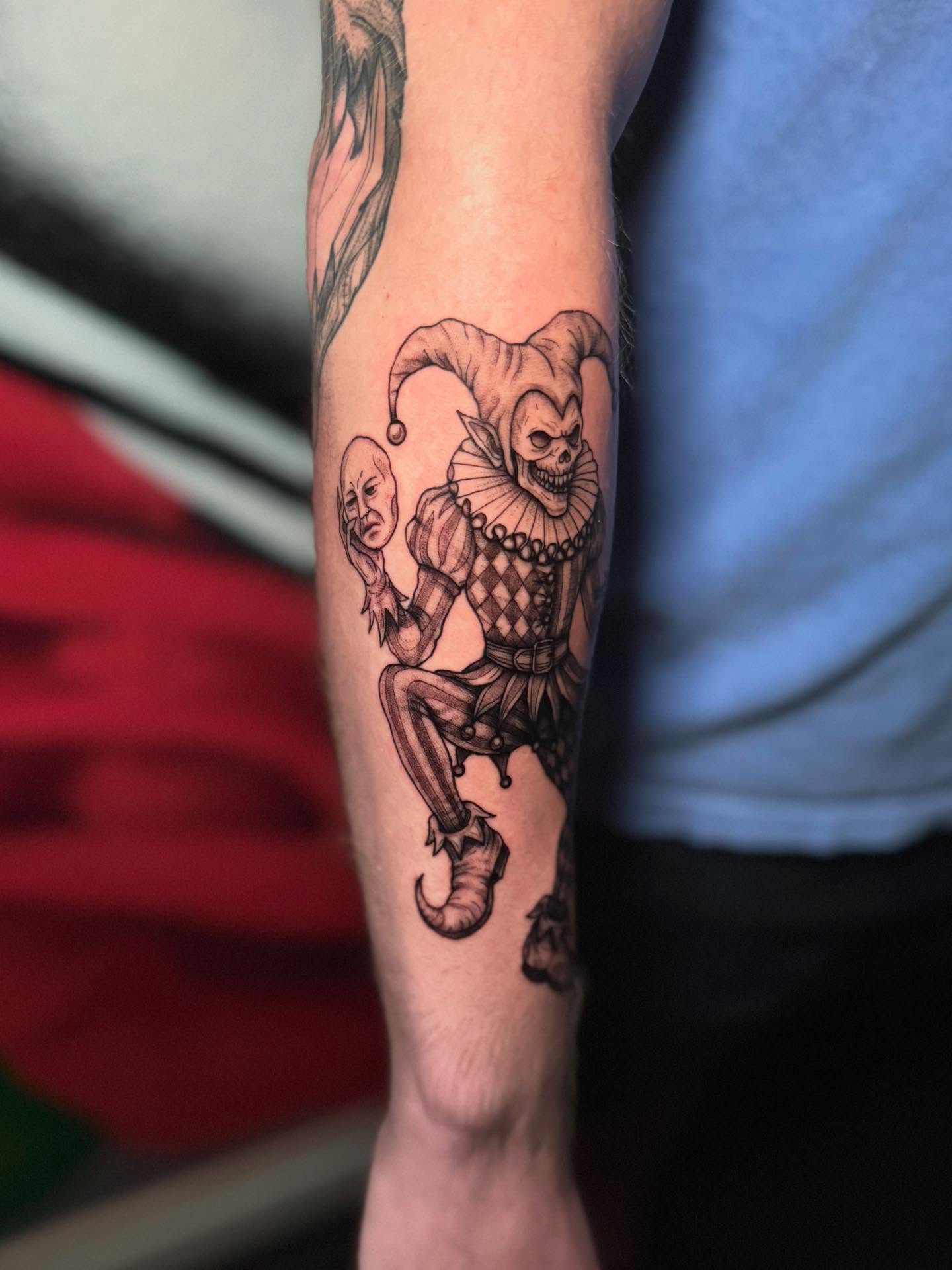 Jester and clown black and grey tattoo on the forearm by Koko