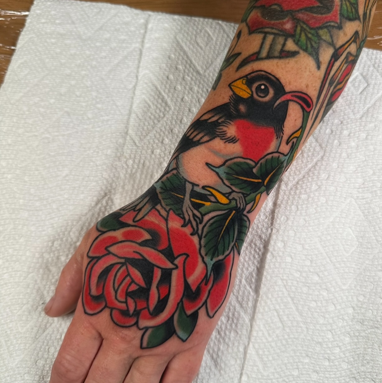 Bird and roses American traditional tattoo on the forearm by Schyler Ames, Canal Fulton, Ohio