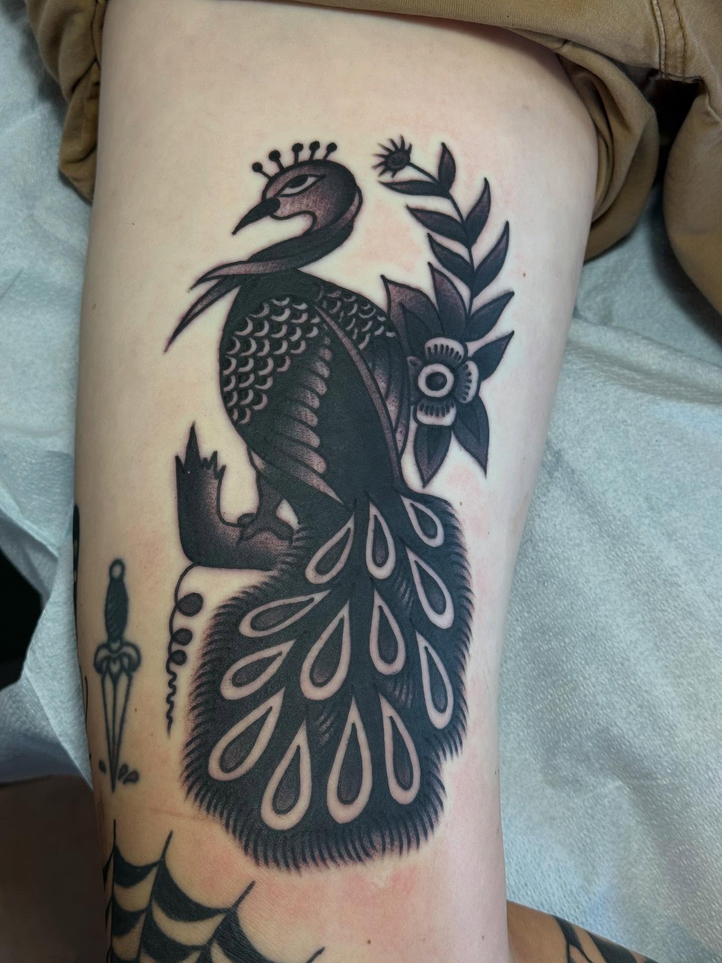 Peacock black and grey tattoo on the thigh by San Diego tattoo artist