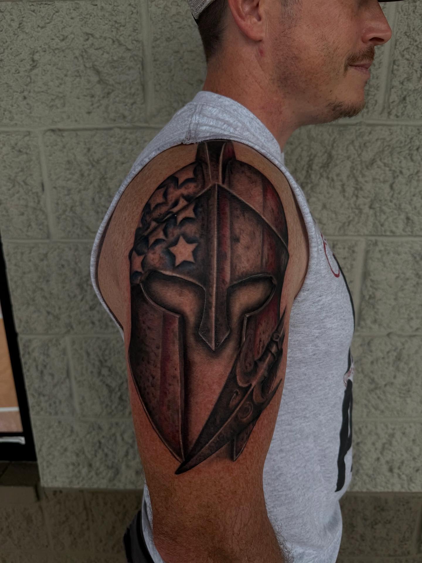 Spartan helmet realism tattoo on the shoulder by Kylee langford 🧿