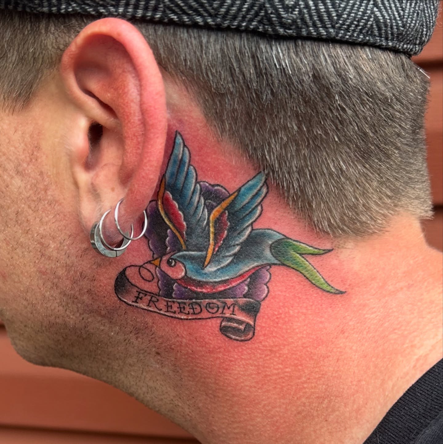 Bird American traditional tattoo on the neck by Bosco Layne