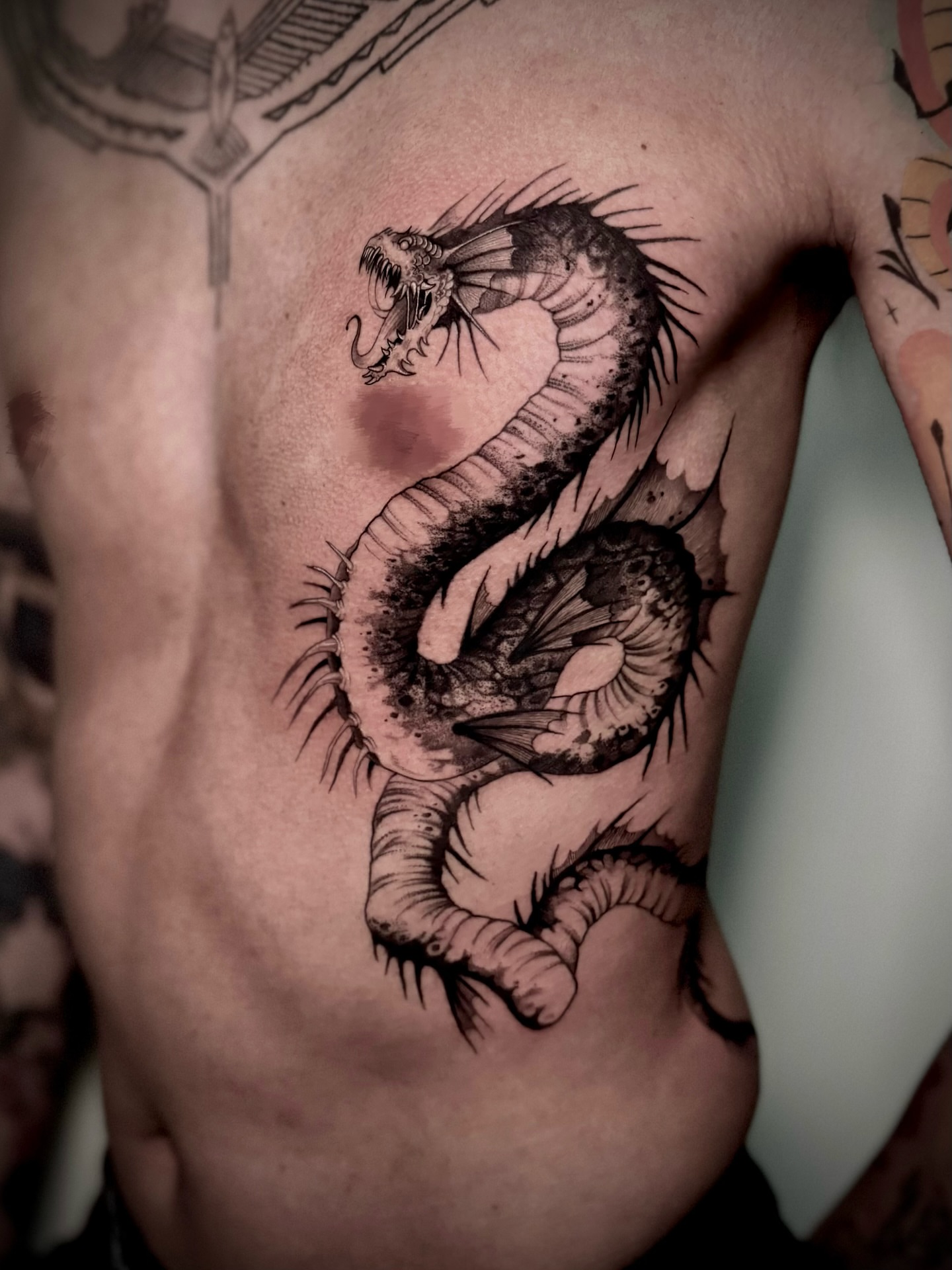 Snake black and grey tattoo on the chest by Melanie