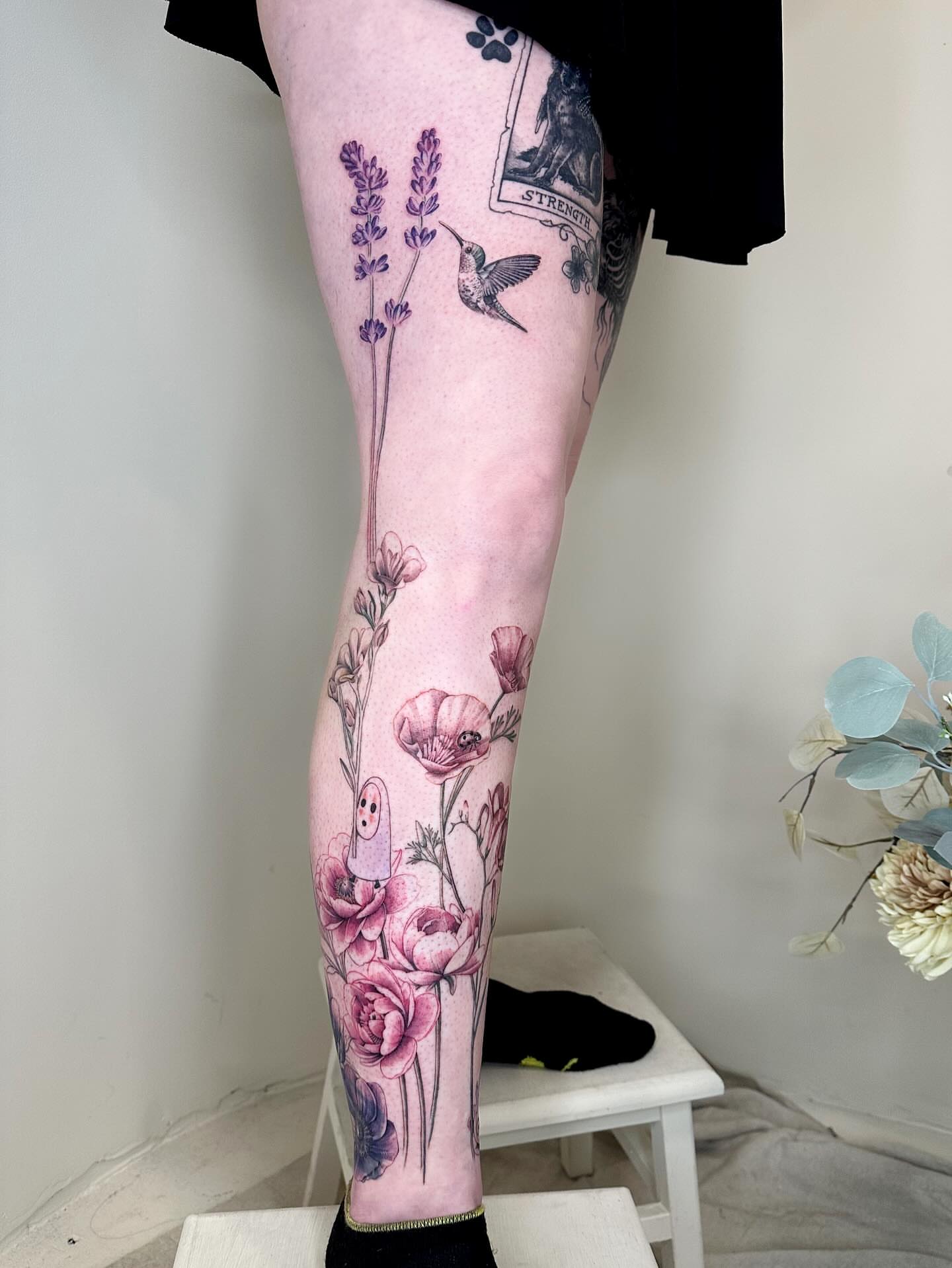 Floral arrangement realism tattoo on the leg by Claire