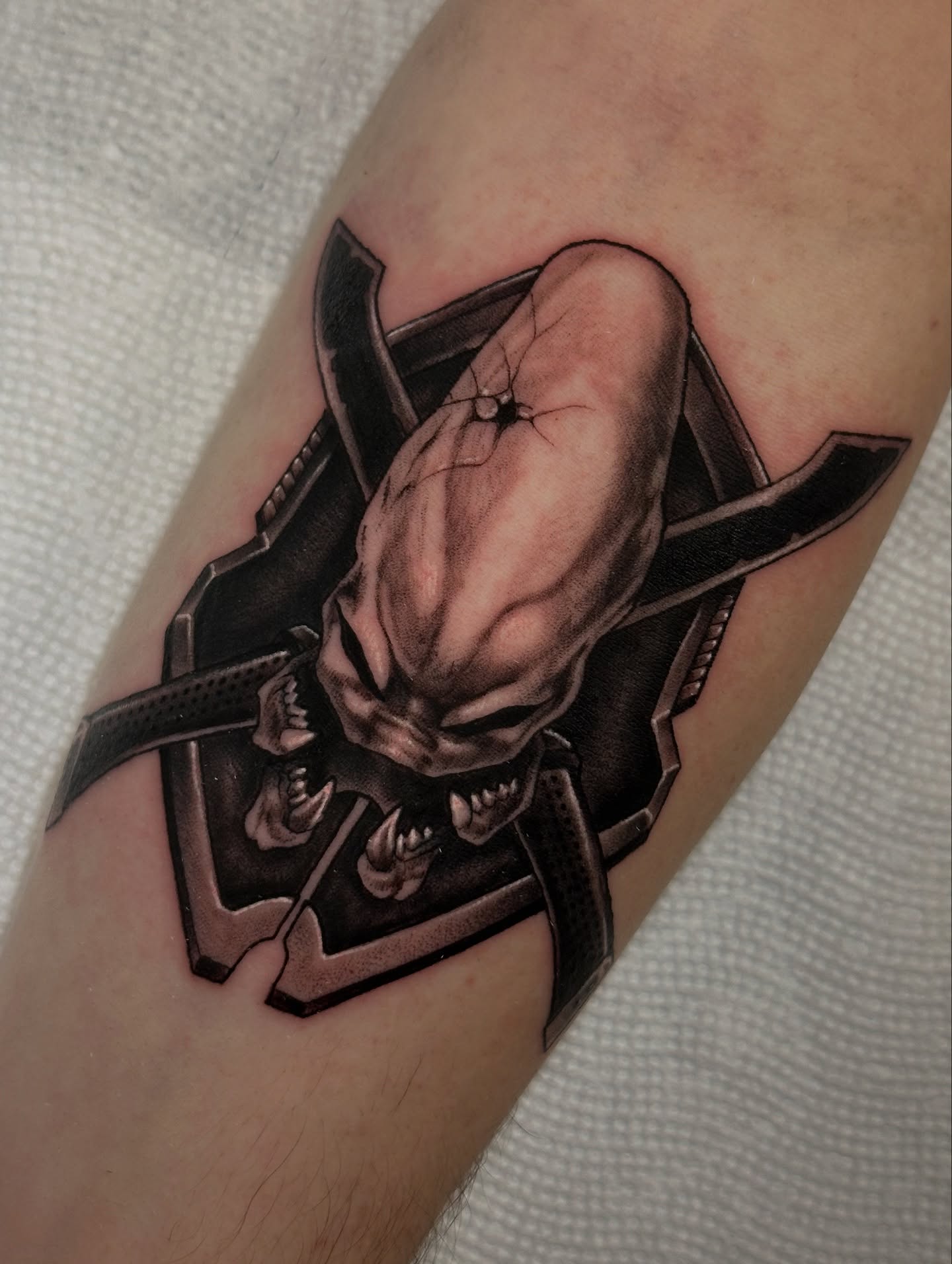 Alien head dark realism tattoo on the forearm by ɢᴀʙʀɪᴇʟ ᴍᴇɴᴅᴇꜱ ᴏʟɪᴠᴇɪʀᴀ