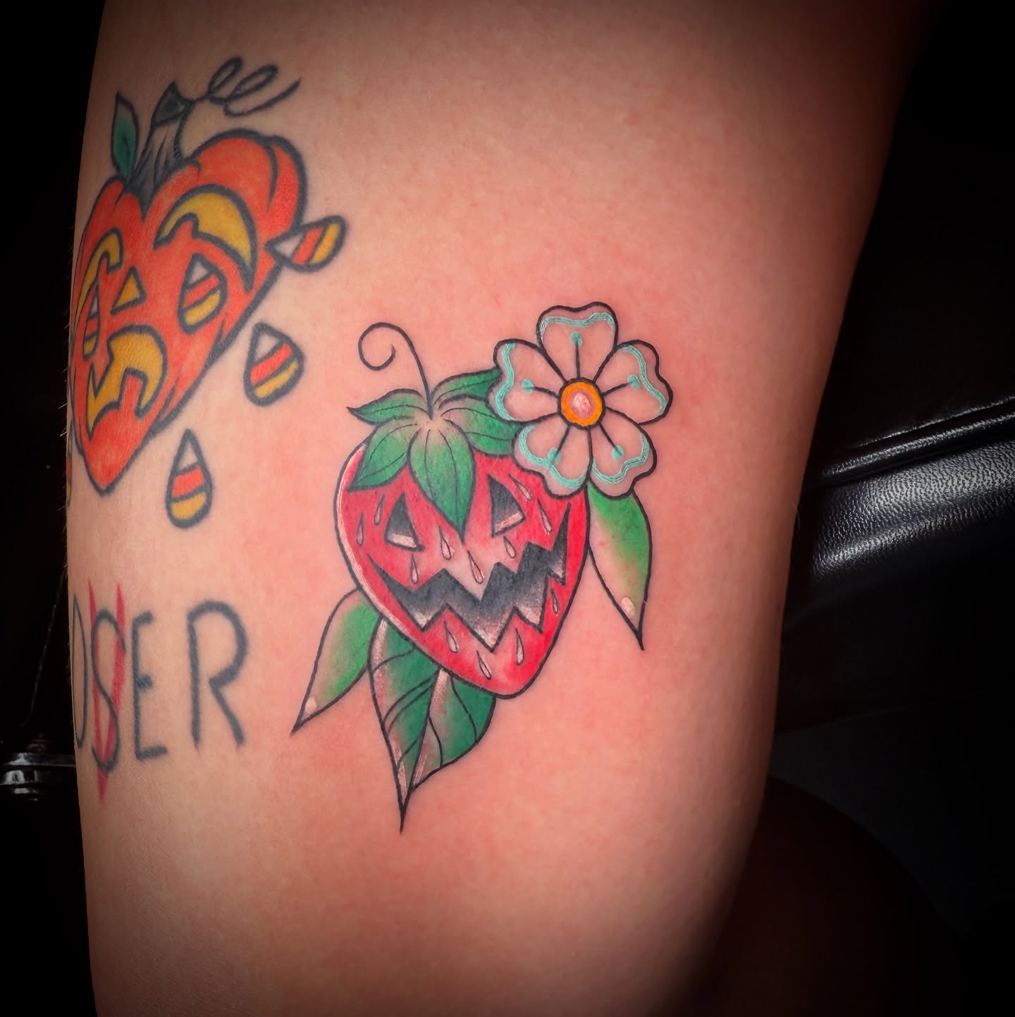 Strawberry and flower American traditional tattoo on the thigh by Tattoo & Body Artist, Gastonia, North Carolina