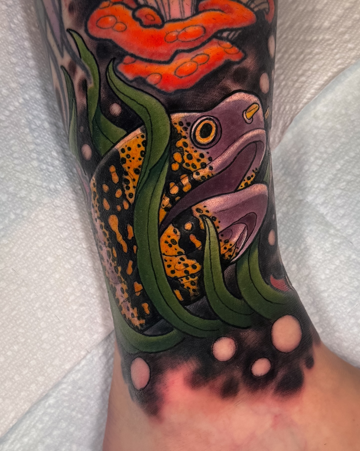 Fish and coral realism tattoo on the forearm by Austin Britt