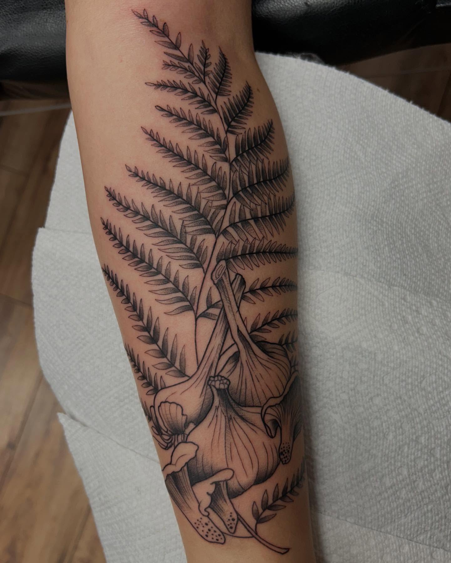 Garlic and fern black and grey tattoo on the forearm by Tiffany Vargas