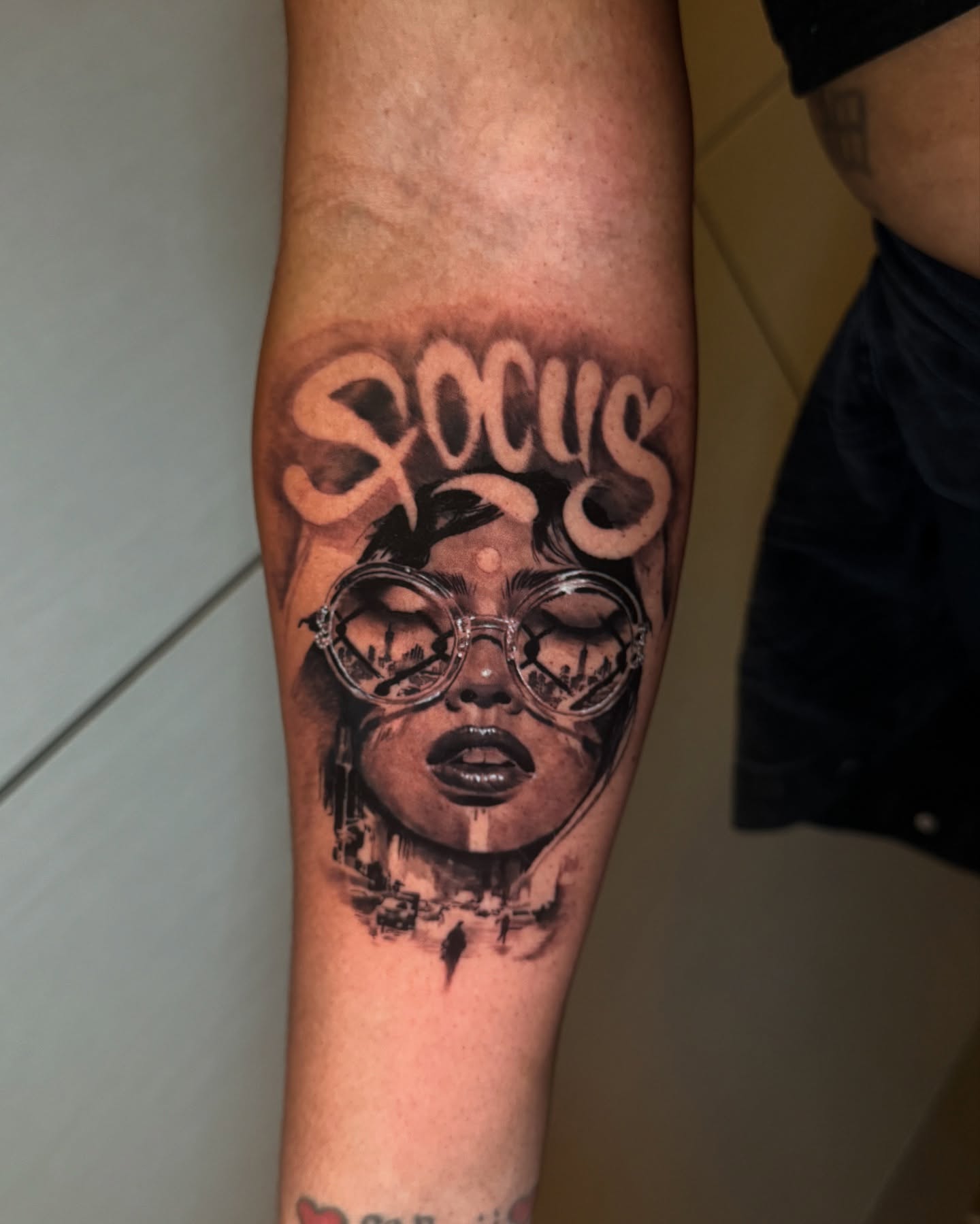 Woman with glasses realism tattoo on the forearm by Joel: Boston Tattoo Artist, Boston, Massachusetts