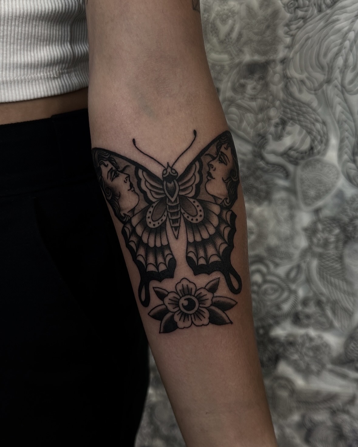 Butterfly and faces black and grey tattoo on the forearm by ππ¦π βπ¬π²π«π±π°