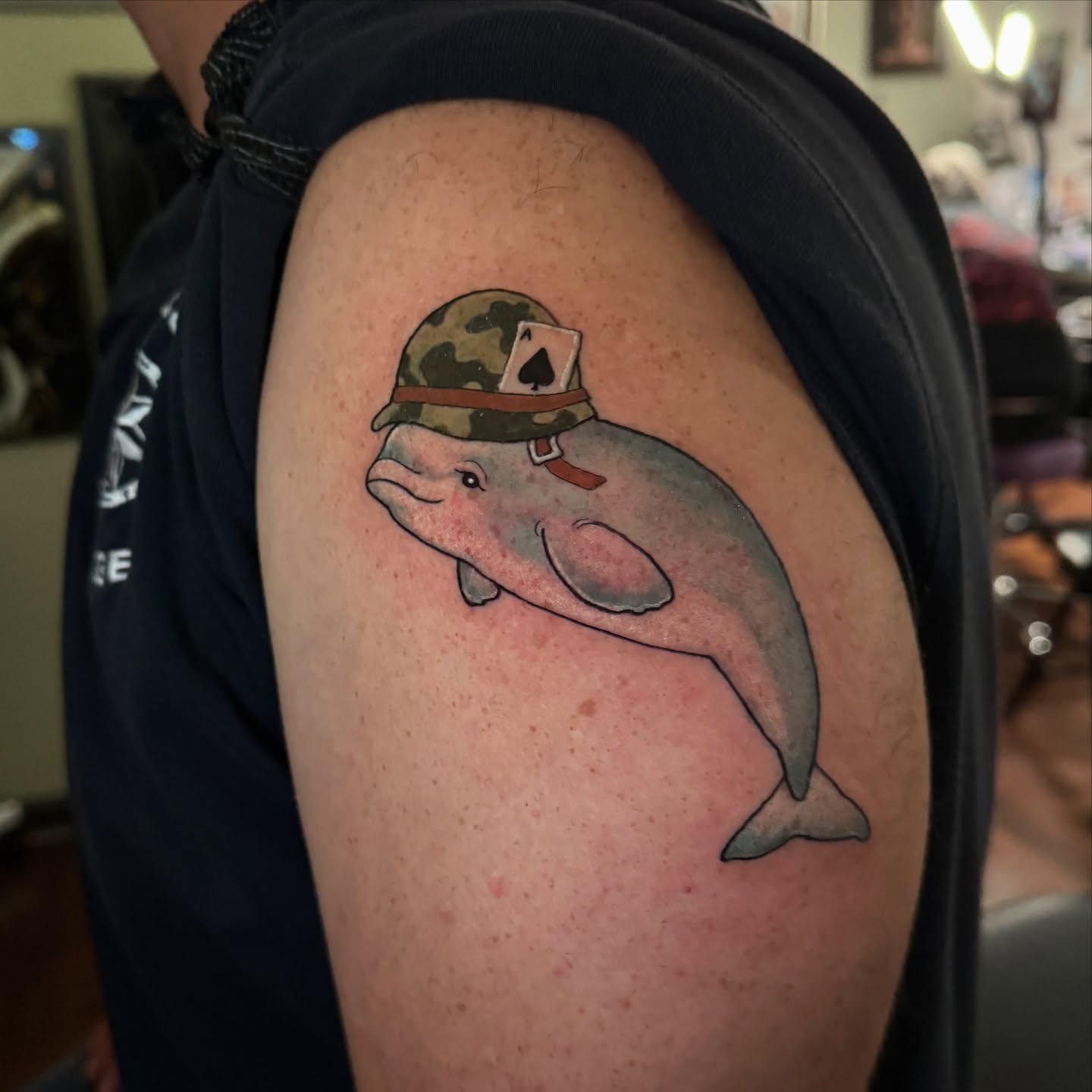Dolphin wearing a camouflage hat realism tattoo on the shoulder by đź’›Kristinađź’› tattoos with intention, Minneapolis, Minnesota